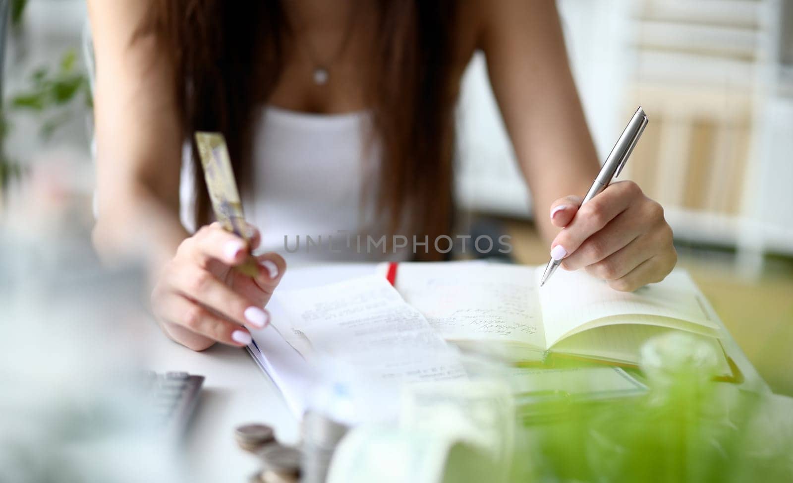 Focus on tender businesswoman hands holding metallic writing pen and counting important numbers in significant charts and graphs. Office concept. Blurred background