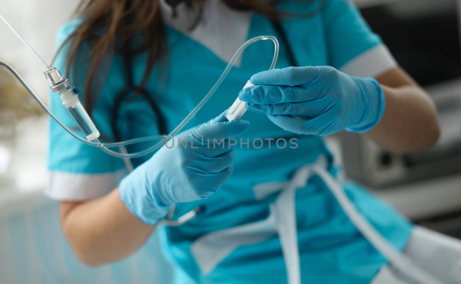 Close-up of female hands in sterile gloves putting dropper to sick patient. First aid procedures. Giving medical care. Healthcare and prevention concept