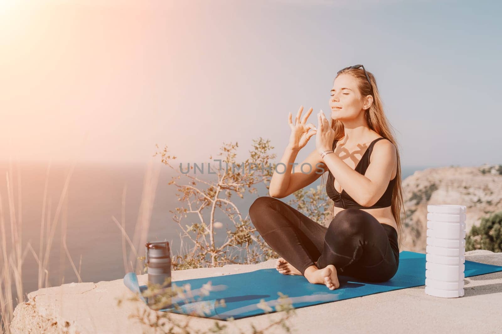 Fitness woman sea. Outdoor workout on yoga mat roller in park near to ocean beach. Female fitness pilates yoga routine concept. Healthy lifestyle. Happy fit woman exercising with rubber band in park. by panophotograph