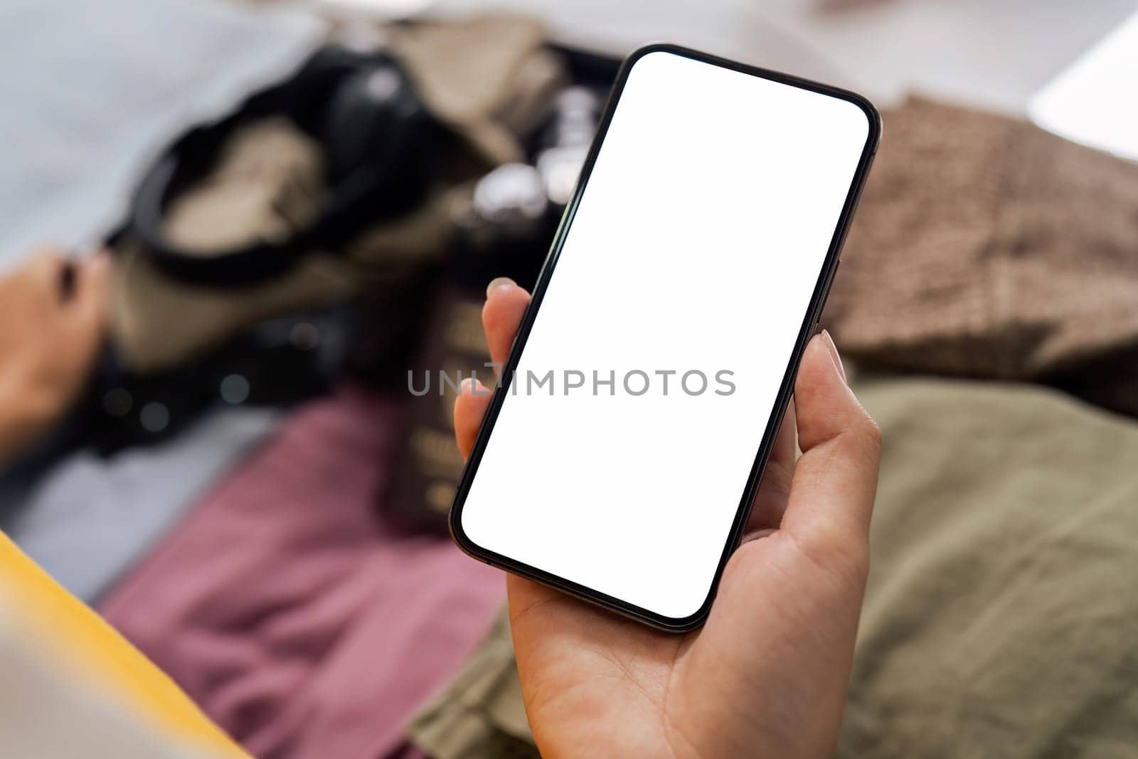 Mockup mobile phone with white screen, luggage in background by itchaznong