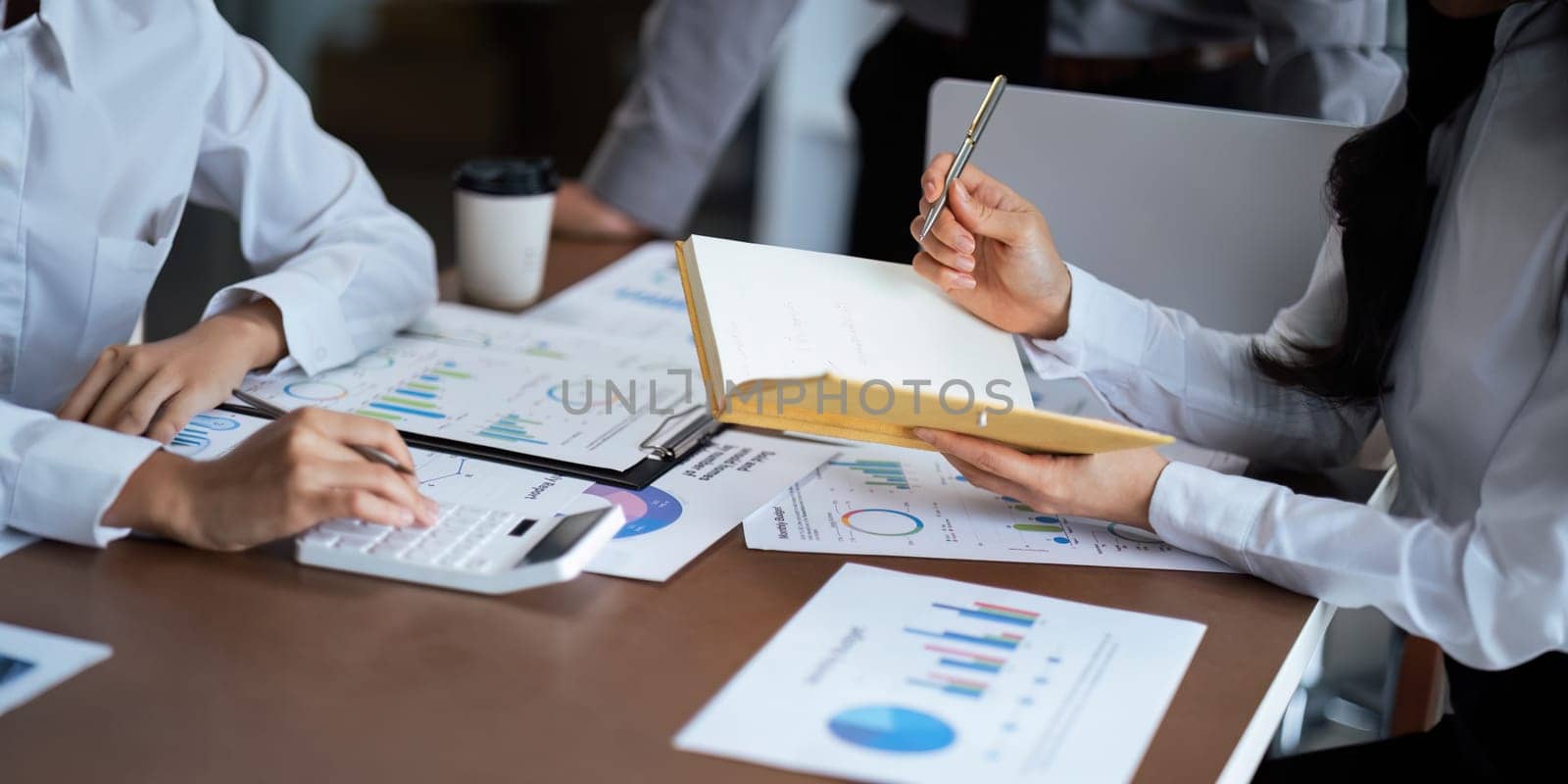 Close up business team analyzes financial business finance reports on laptop and graph documents during corporate meeting discussion showing successful teamwork, business meeting ideas.