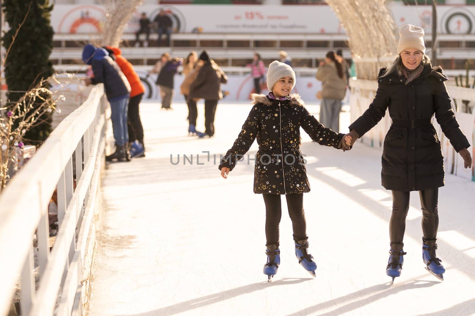 Mother with her daughters skates on ice skating by Andelov13