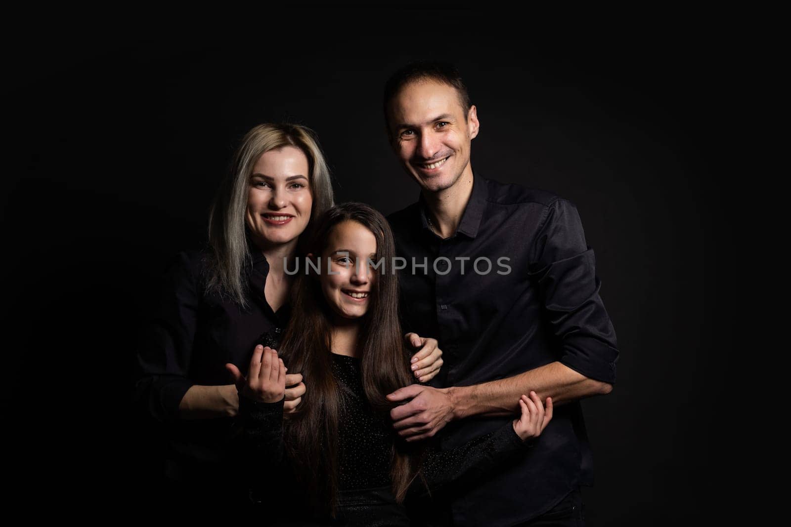 happy family mother, father, daughter on a black background.