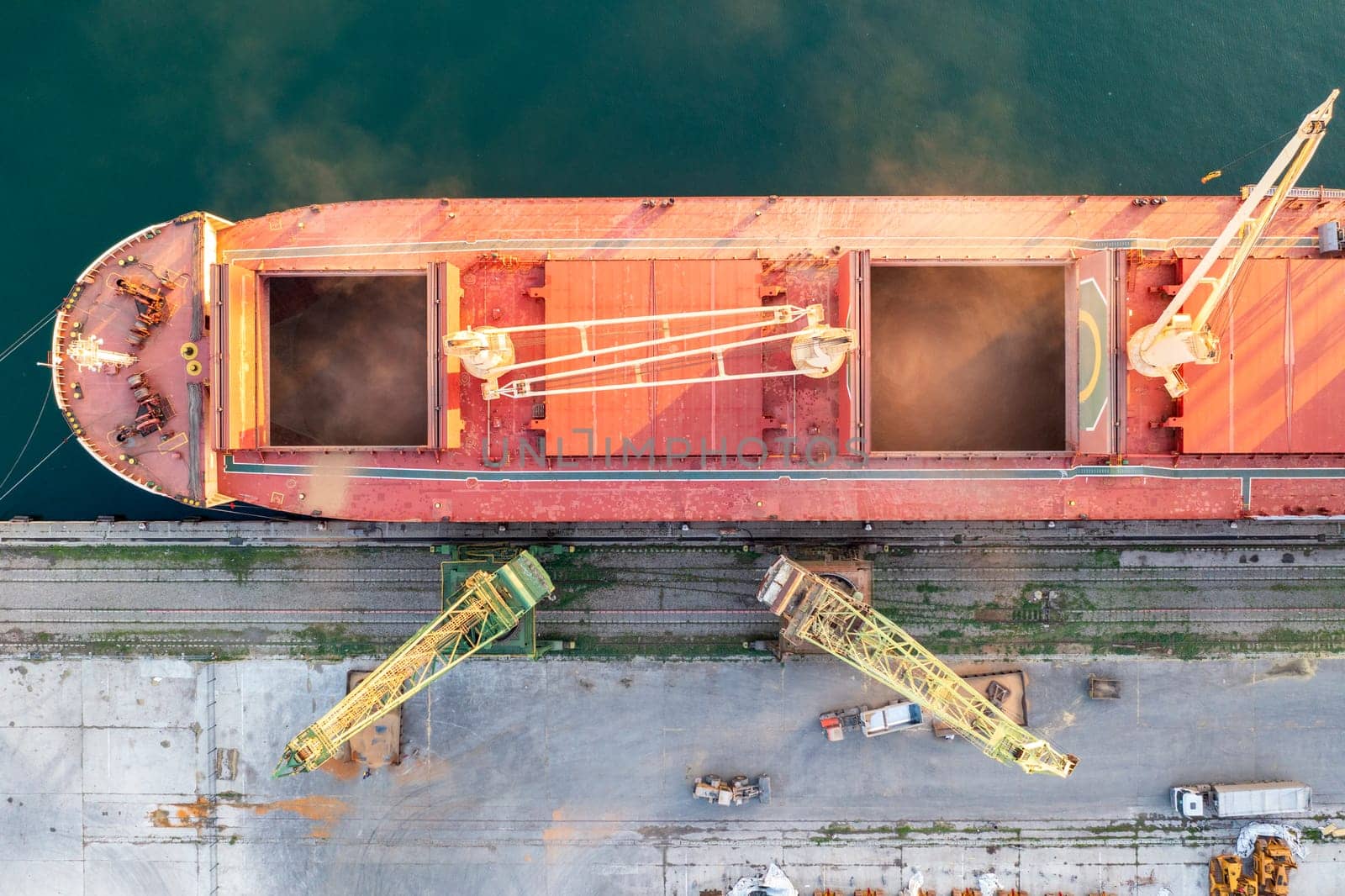 Top view from a drone of a large ship loading grain for export. Water transport