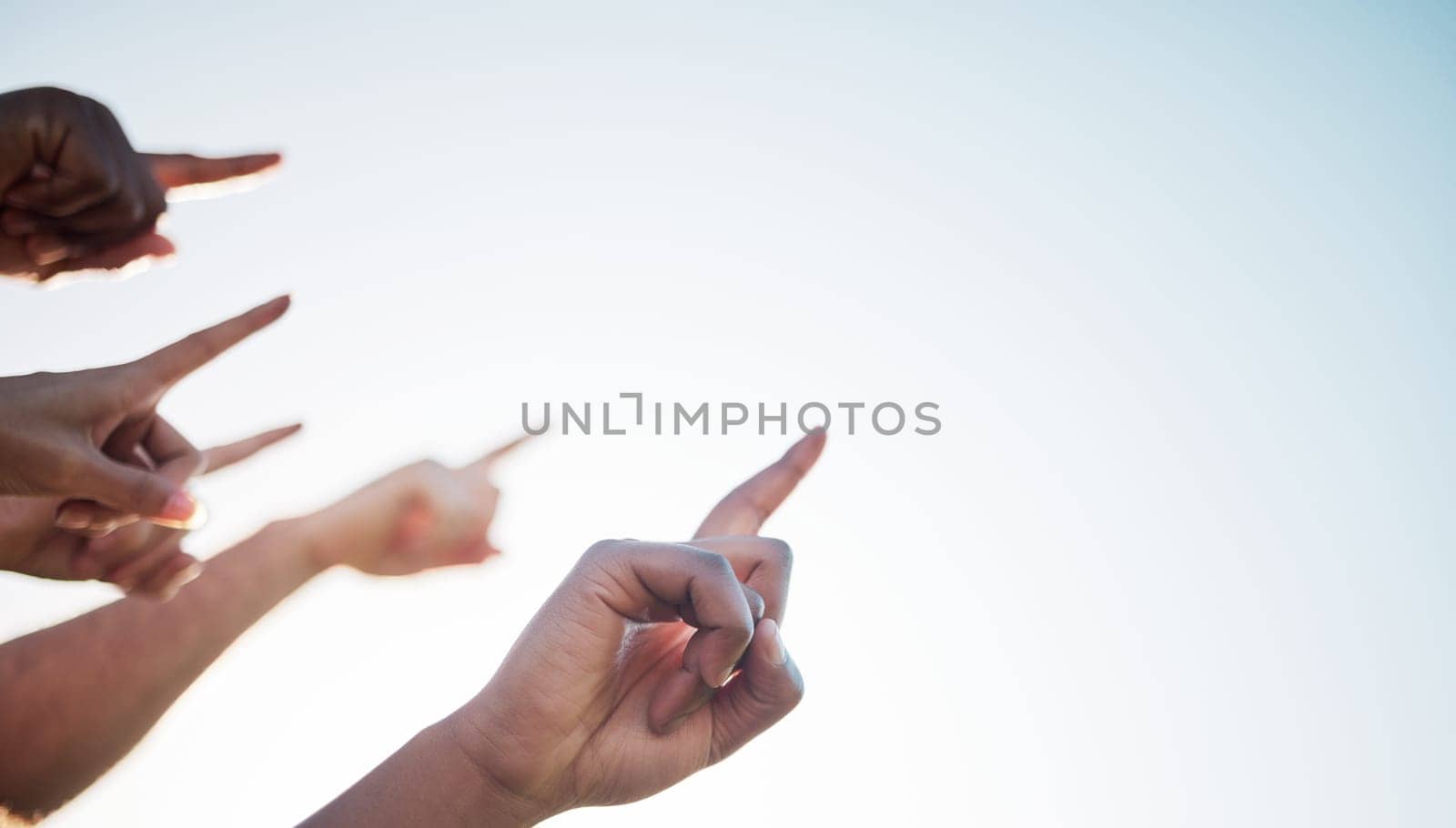 Fingers, closeup and pointing to sky mockup, collaboration and direction for climate change. Group of diverse hands, wellness, teamwork and solidarity for message in marketing, advertising or vision by YuriArcurs