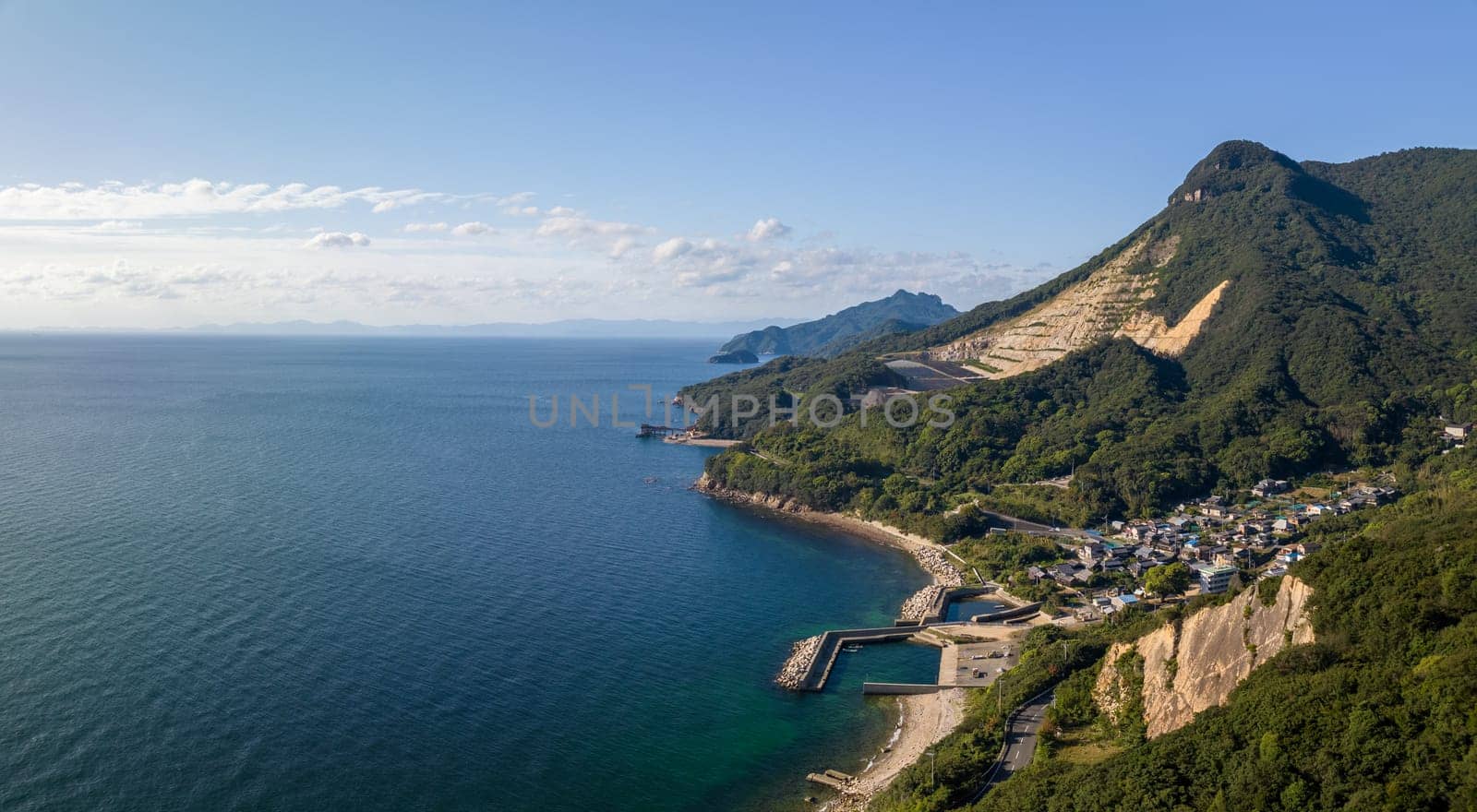 Panoramic aerial view of mountain strip mines by coastal town and harbor. High quality photo