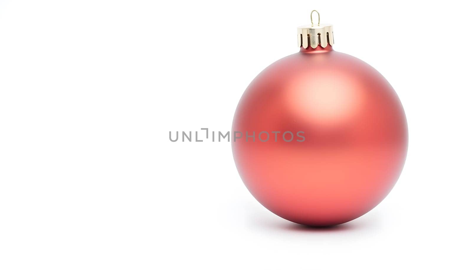 A single red Christmas ornament isolated on a white background, reflecting light and showcasing intricate details. Perfect for festive designs and holiday themes