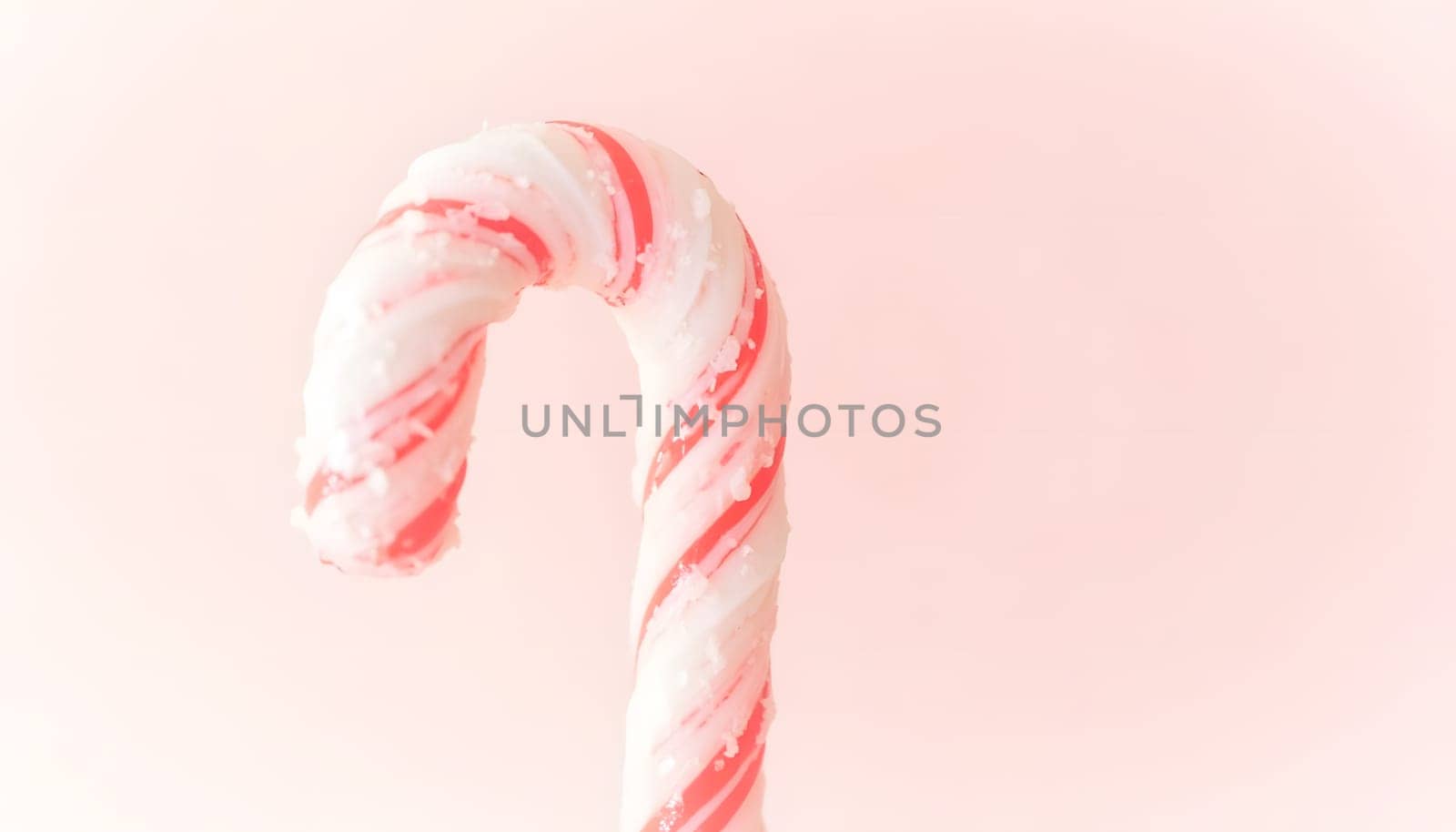 A close-up of a candy cane, isolated against a white or red background, showcasing its vibrant colors and swirling pattern. Perfect for holiday themes and festive visuals