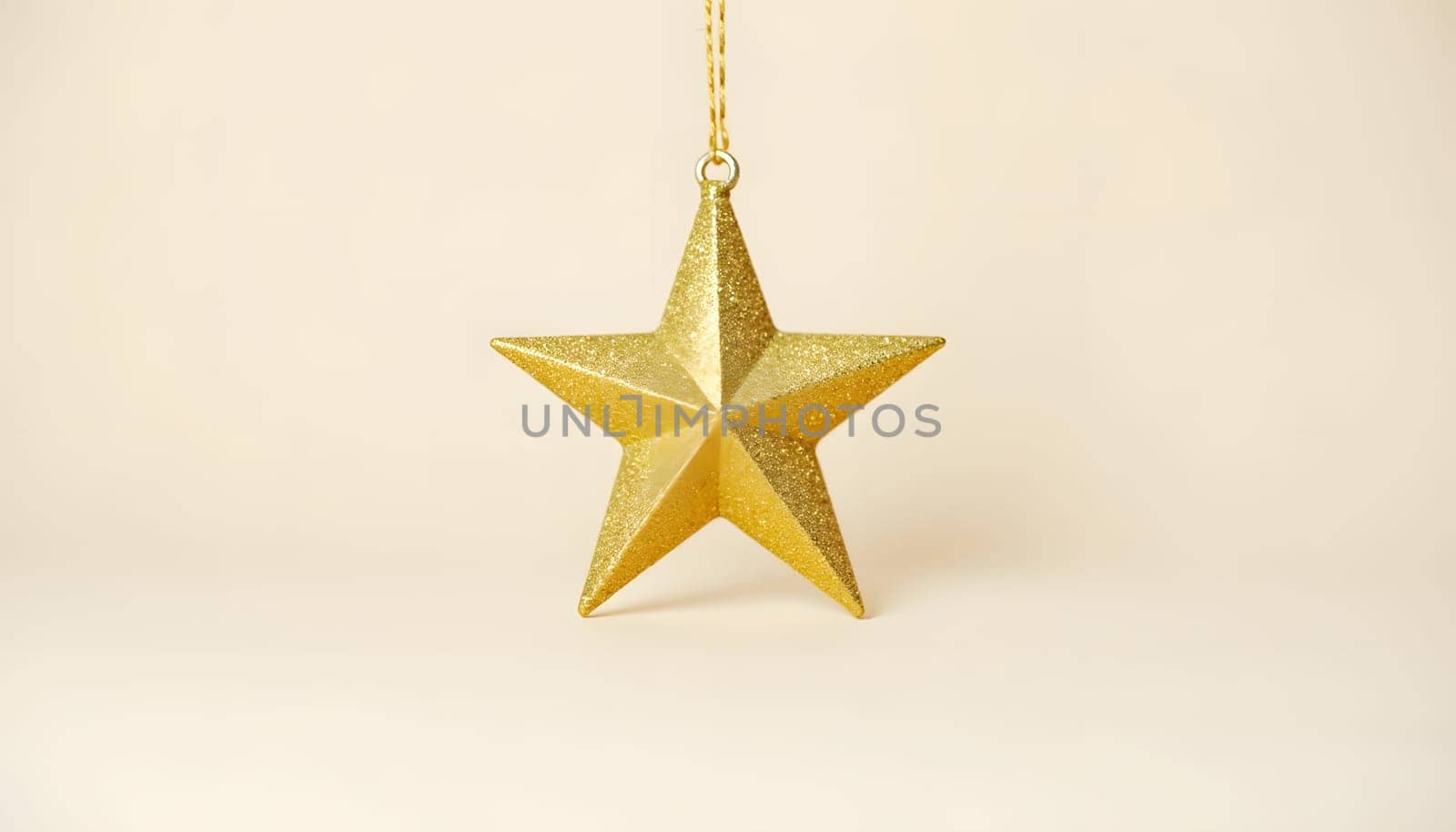 A Christmas star ornament, crafted in glittering gold, isolated on a plain background to showcase its sparkle and shape. Perfect for holiday themes and festive elegance