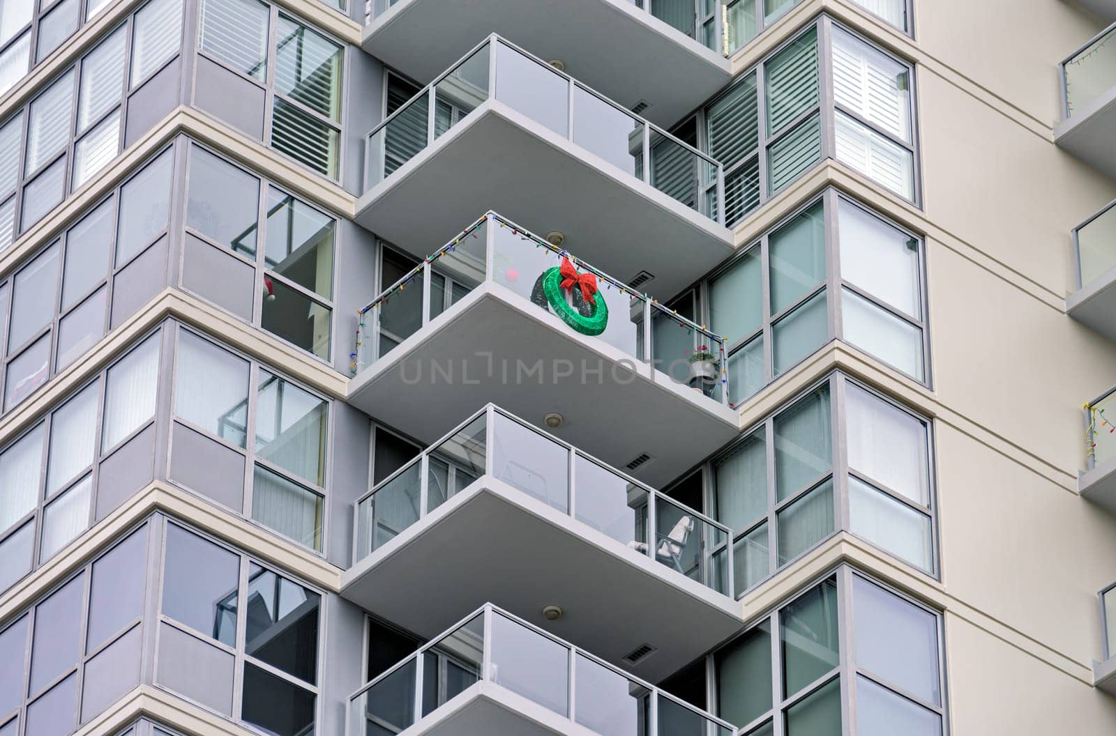 Corner of a residential high-rise building with balconies decorated for Christmas celebration