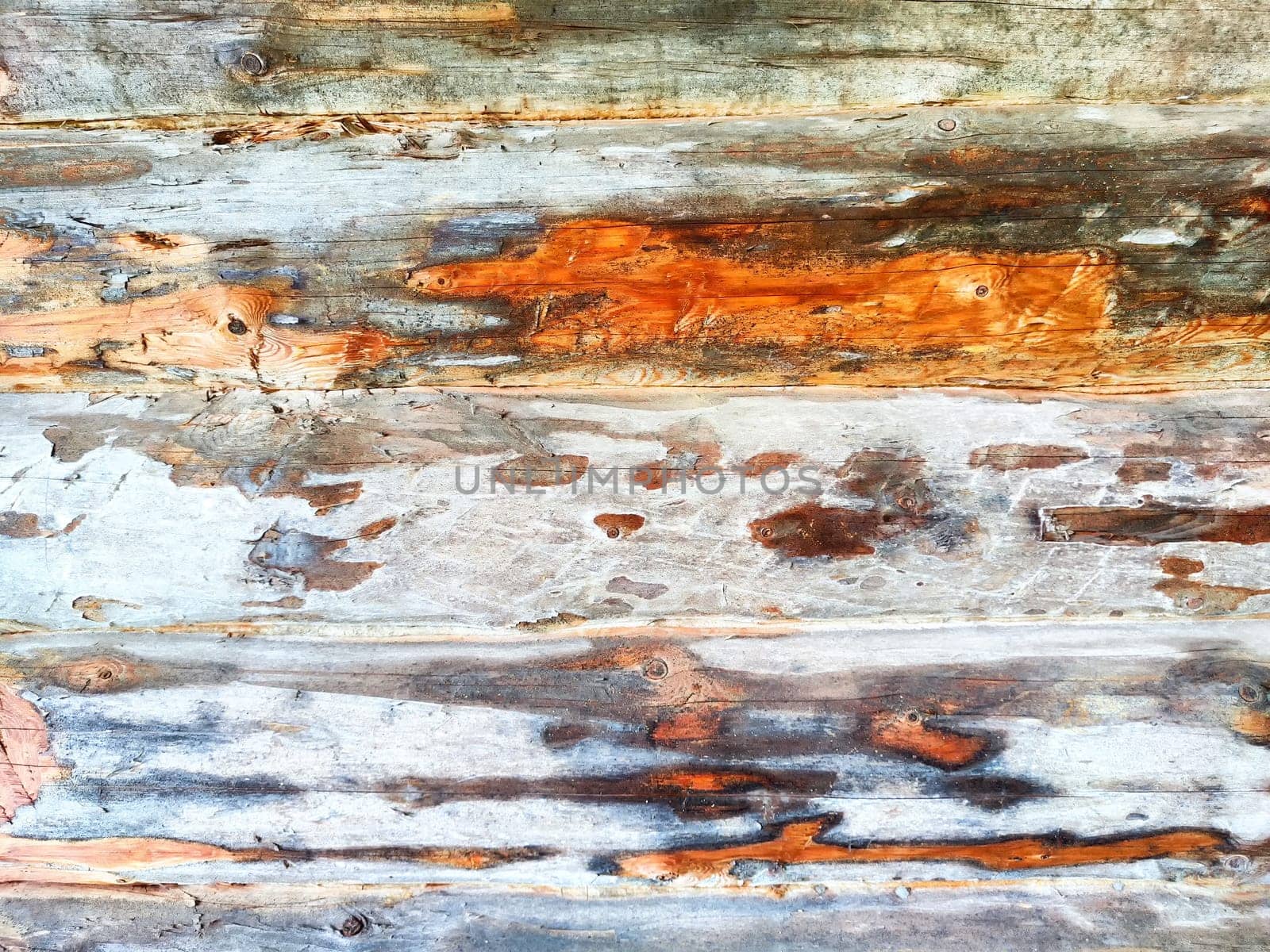 A textured wood surface showcases vibrant patterns and natural wear, ideal for backgrounds and creative projects.
