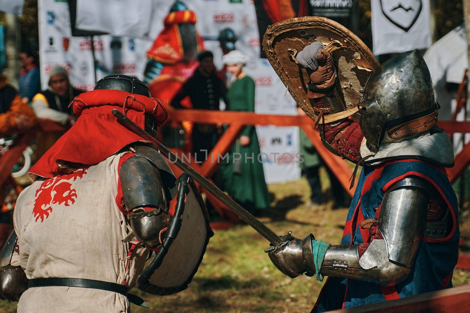 Reconstruction of medieval jousting matches. Battle of two knights from different historical clubs in the arena. Sword fighting. Bishkek, Kyrgyzstan - October 13, 2019