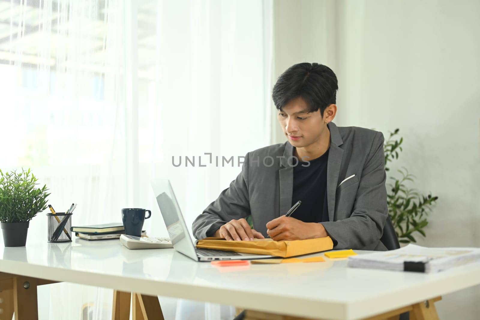 Young entrepreneur managing document folders in office.