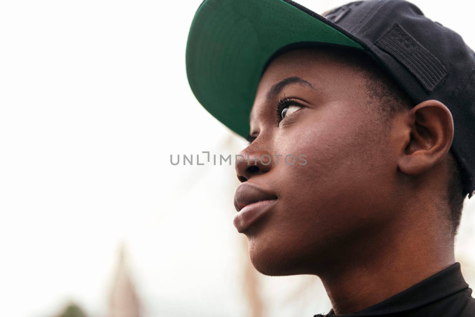 close up profile portrait of a cool african american young woman wearing a cap, copy space for text