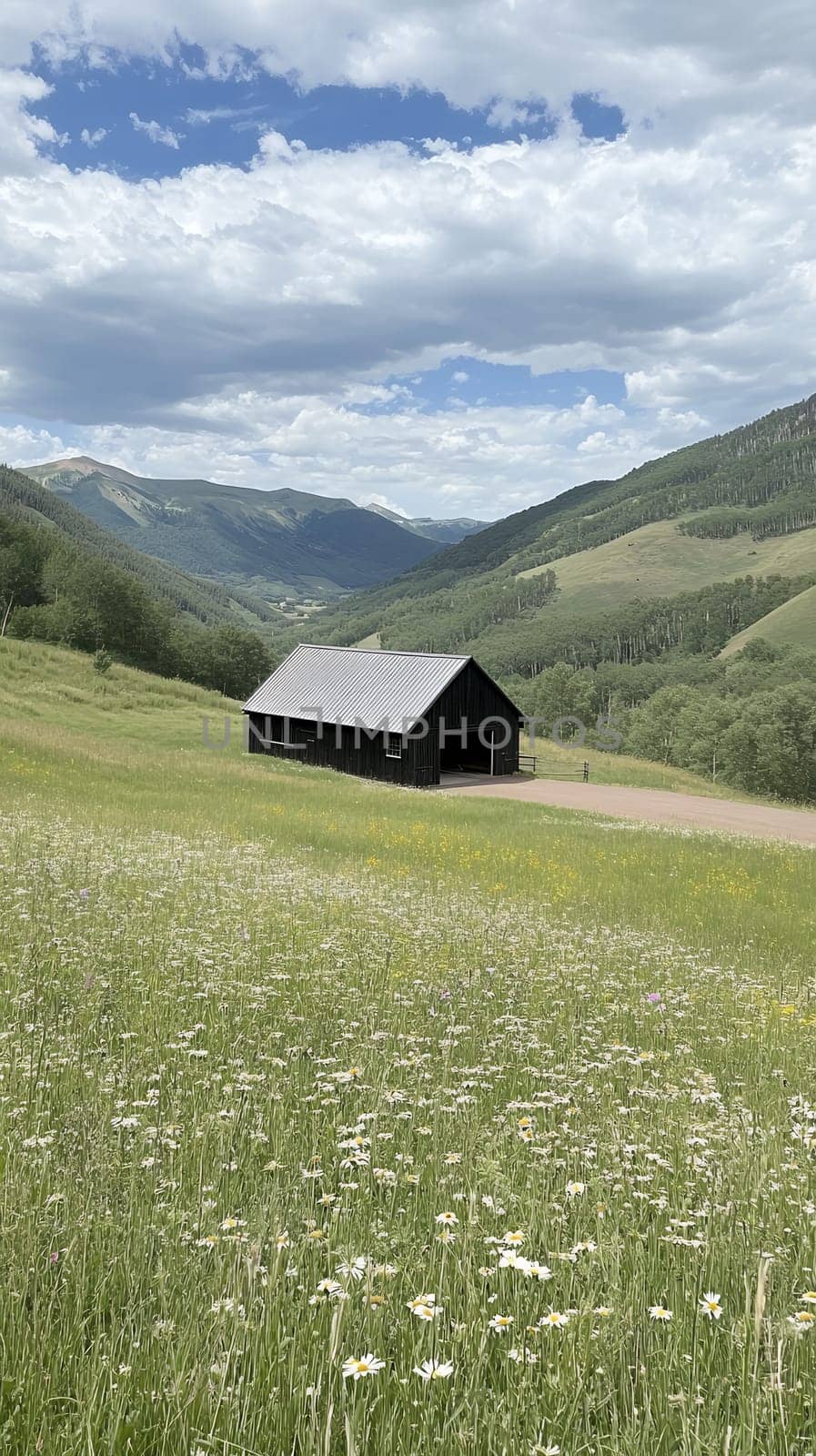 A rustic wooden barn sits peacefully in a lush mountain valley, surrounded by vibrant green fields.