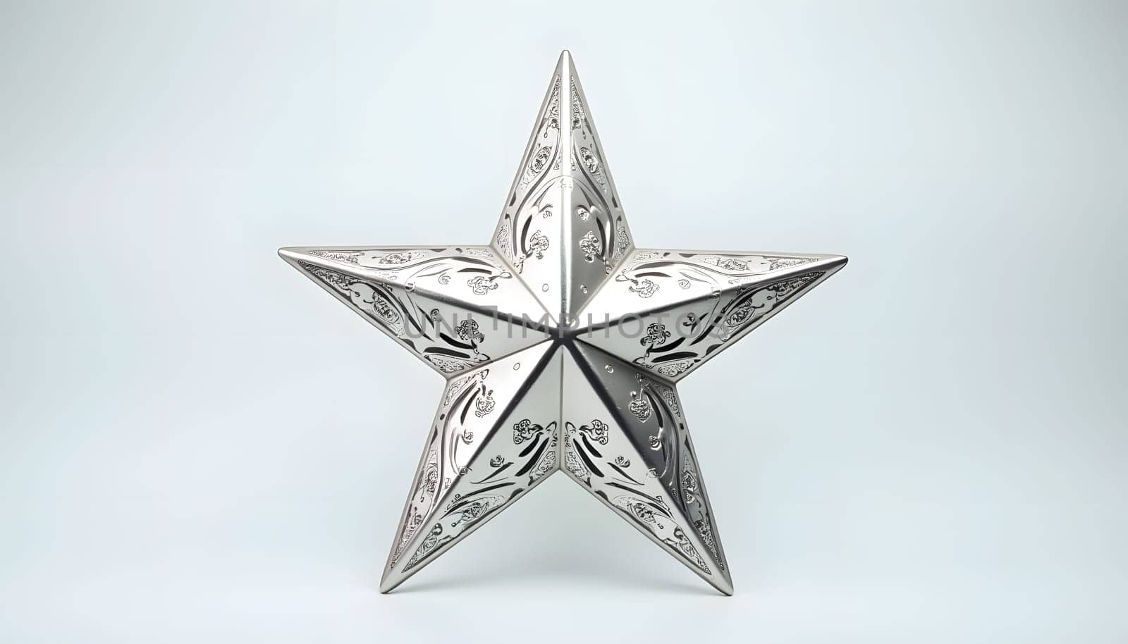A shiny silver Christmas star, isolated against a plain background, with intricate engraved patterns that capture the light. Ideal for festive decorations and holiday elegance