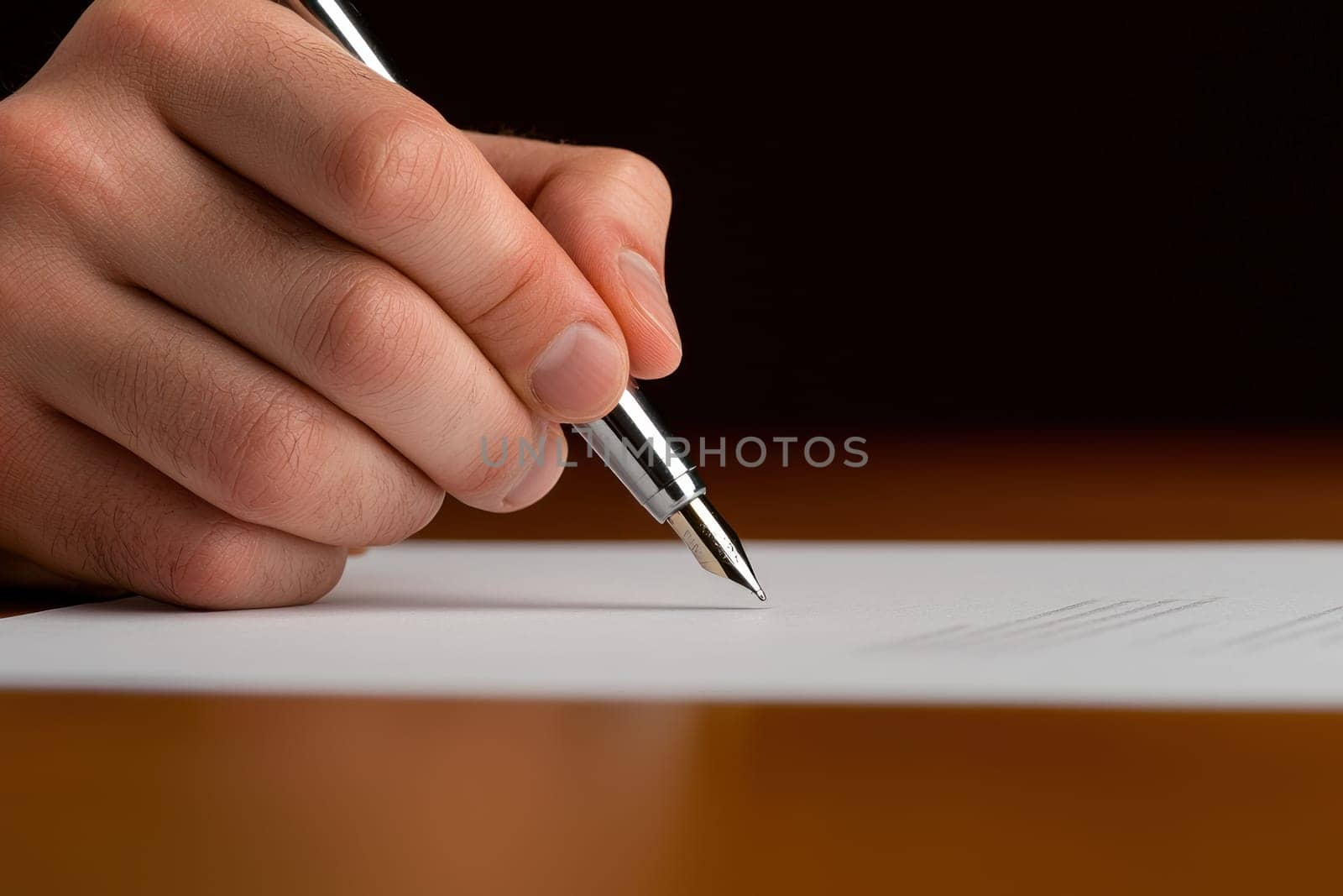Close up of hand holding pen, signing document with focus.