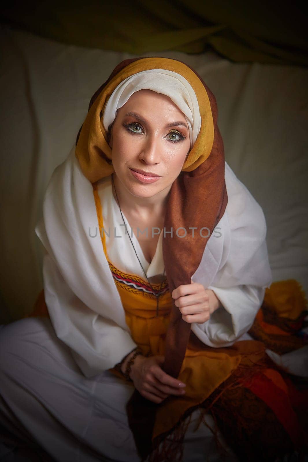 A girl dressed in stylized national clothing of eastern cultures poses elegantly, embodying the character of Rebekah from the Christian Bible.