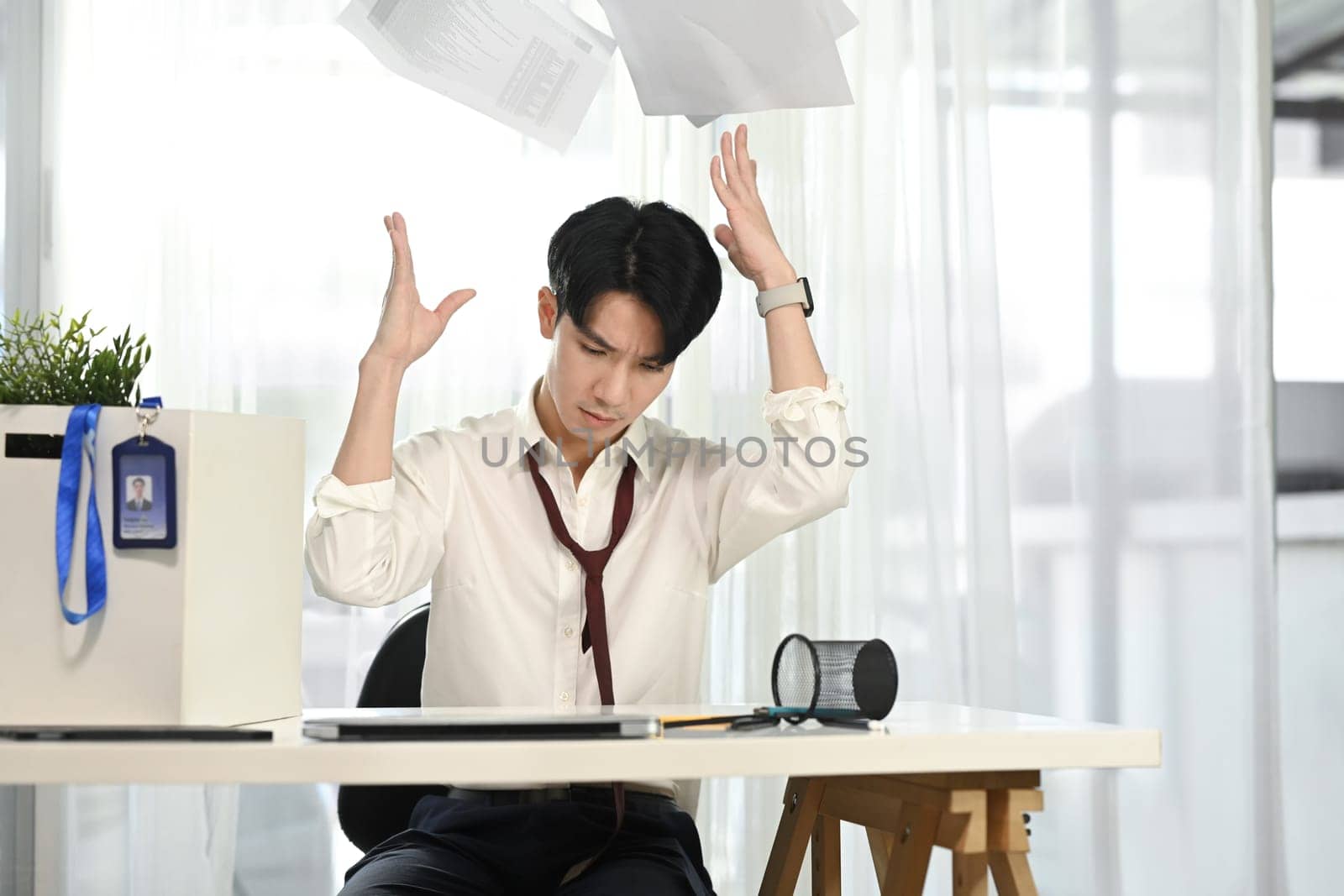 Frustrated office worker throwing documents in anger. Stress at work concept.
