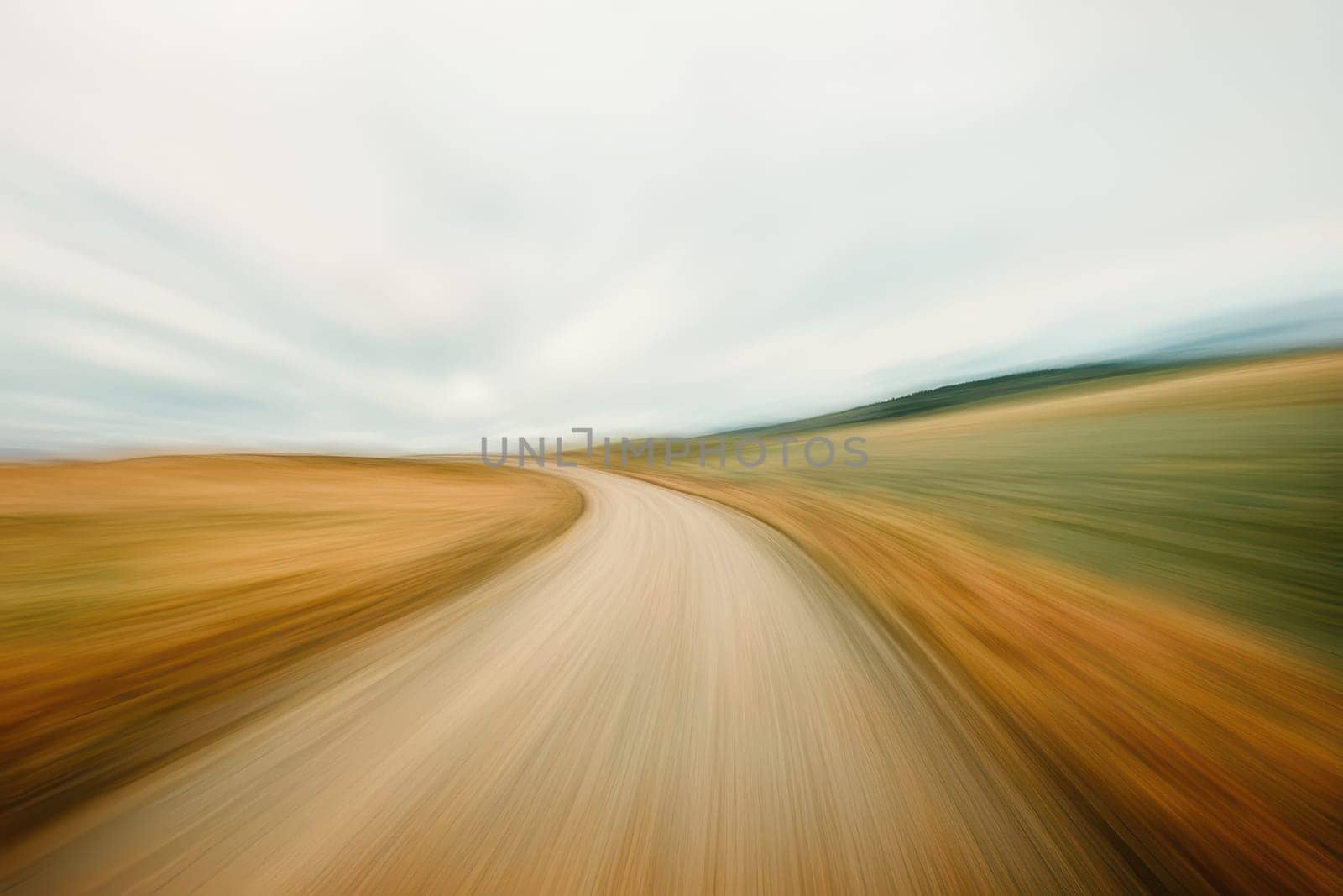 Captured in motion, this abstract image features a blurred road leading into a serene horizon, evoking a sense of speed and adventure in nature.