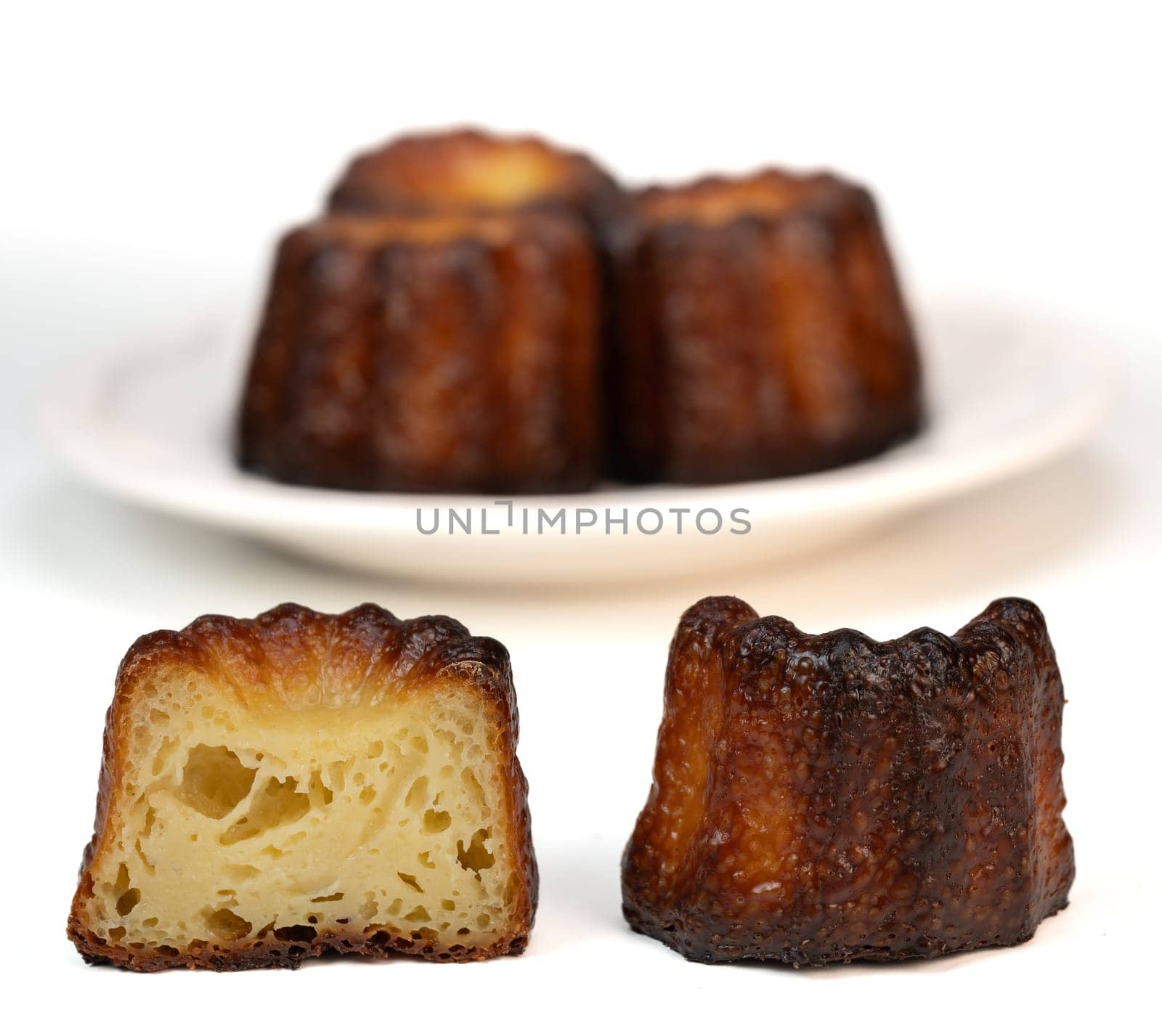 Caneles de bordeaux, traditional French sweet dessert with white table background, High quality photo