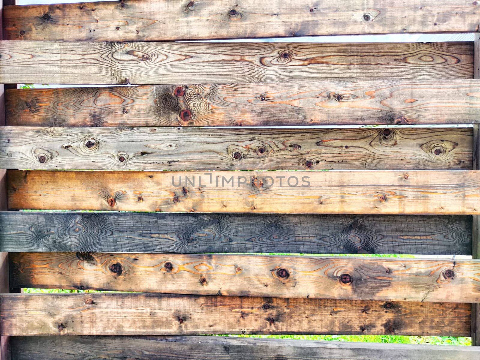 A collection of wooden boards is positioned horizontally, featuring various shades and grains, perfect for a design project or presentation backdrop.