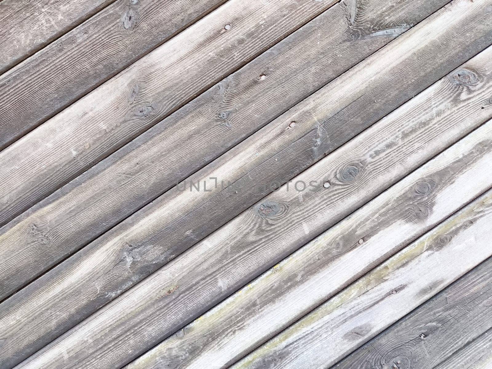 A textured wooden surface features diagonal planks, showcasing natural wear and providing a clean area for text or graphics.