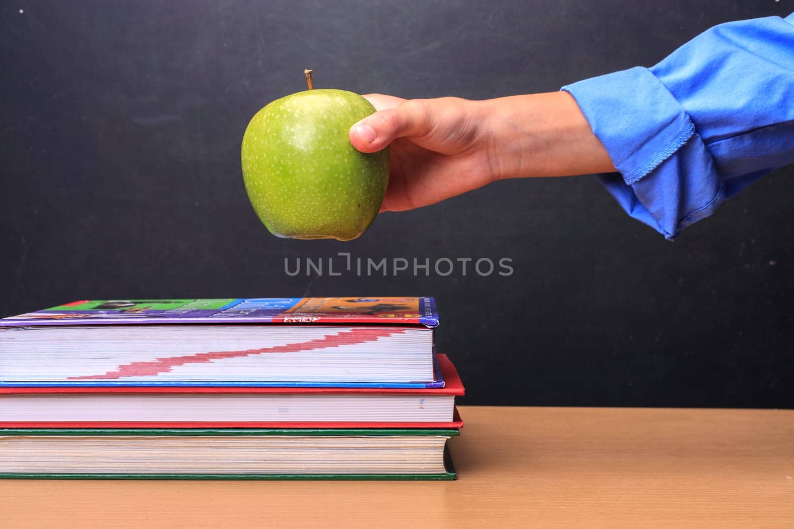 A concept image of a student putting an apple on a teachers desk.