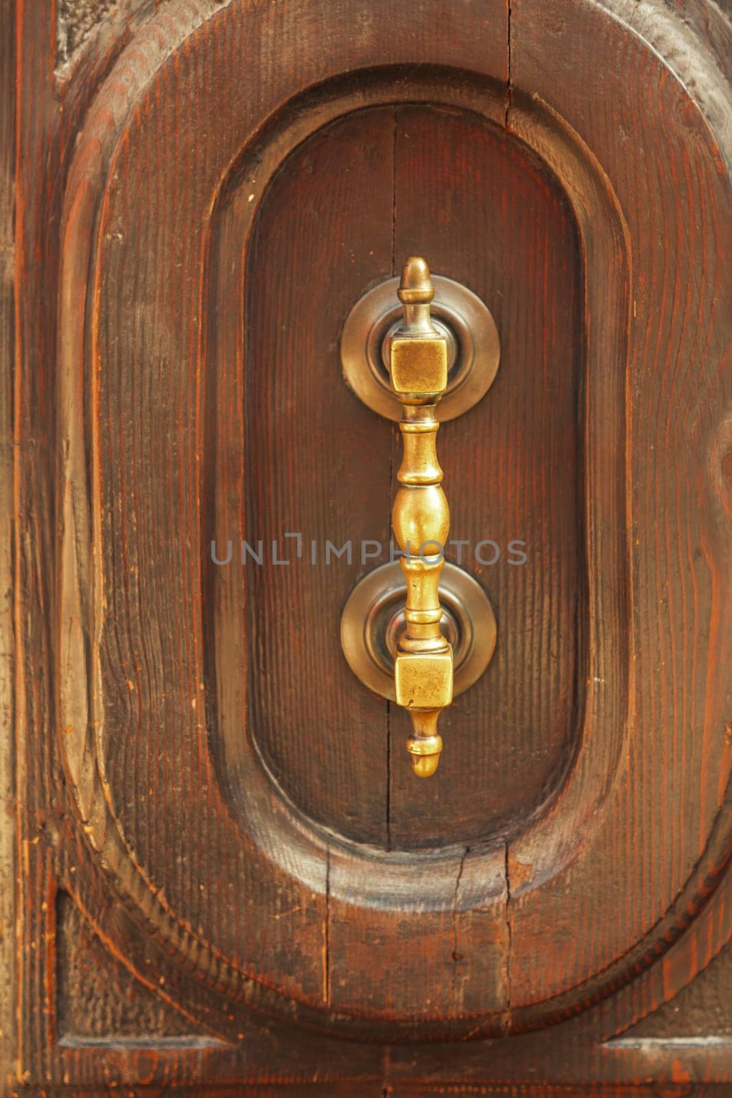 Fragment of an old wooden door with a metal handle.