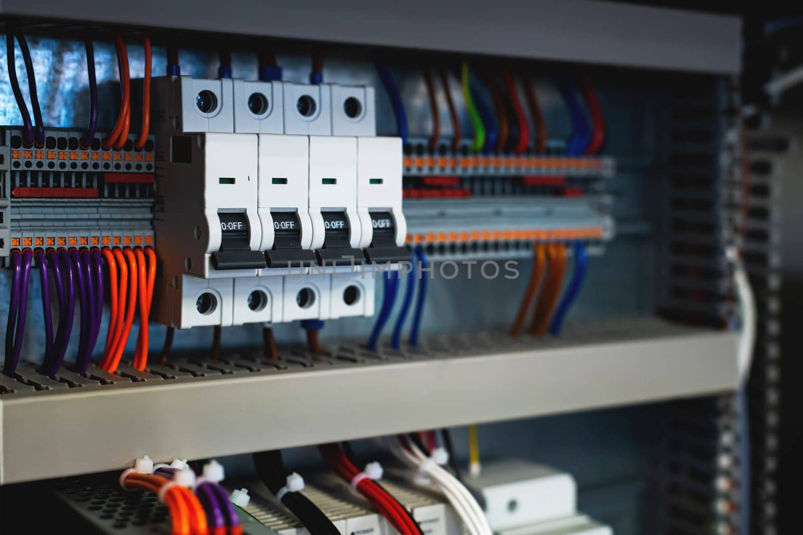 Several batch switches in an electrical control cabinet on a production line, surrounded by inverters and control wiring. selective focus.