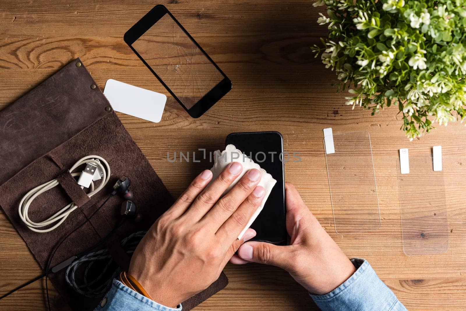 The man replacing the broken tempered glass screen protector for smartphone.