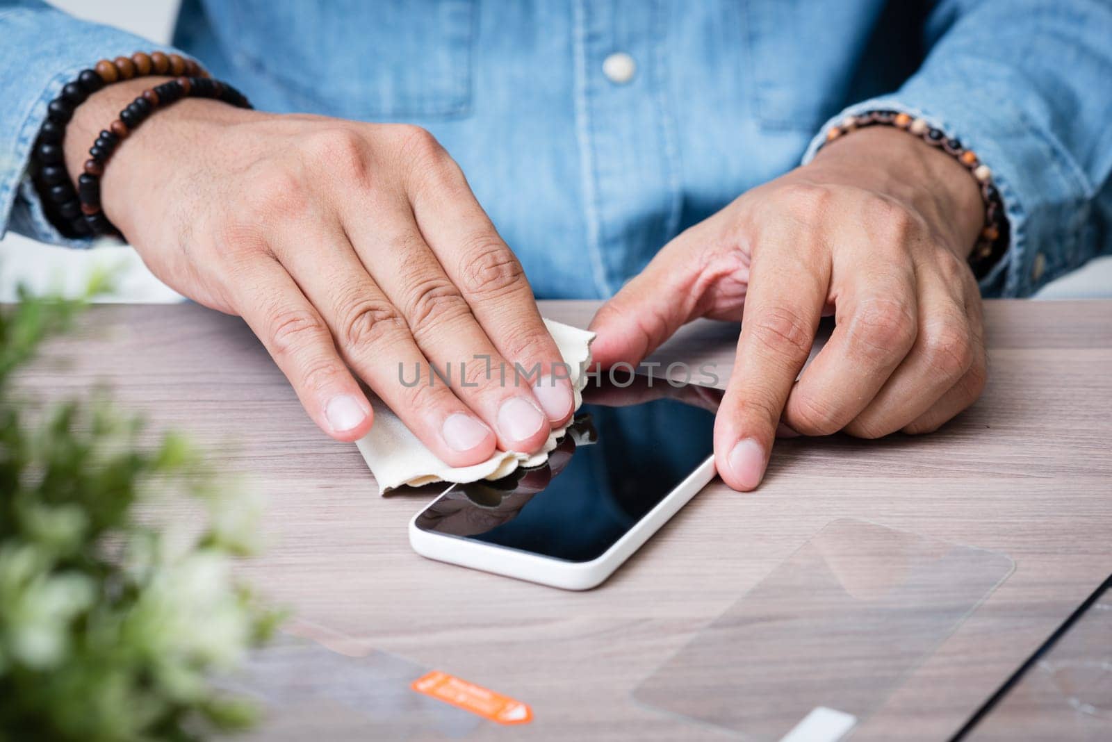 The man replacing the broken tempered glass screen protector for smartphone.