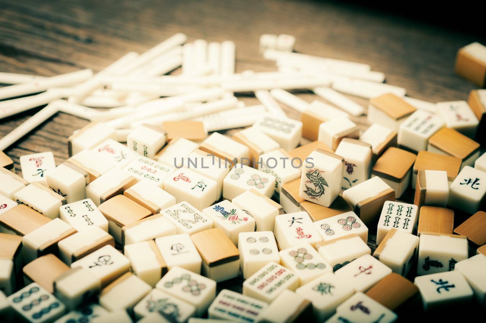 Many old mahjong tiles on wooden table. Mahjong is the ancient asian board game.