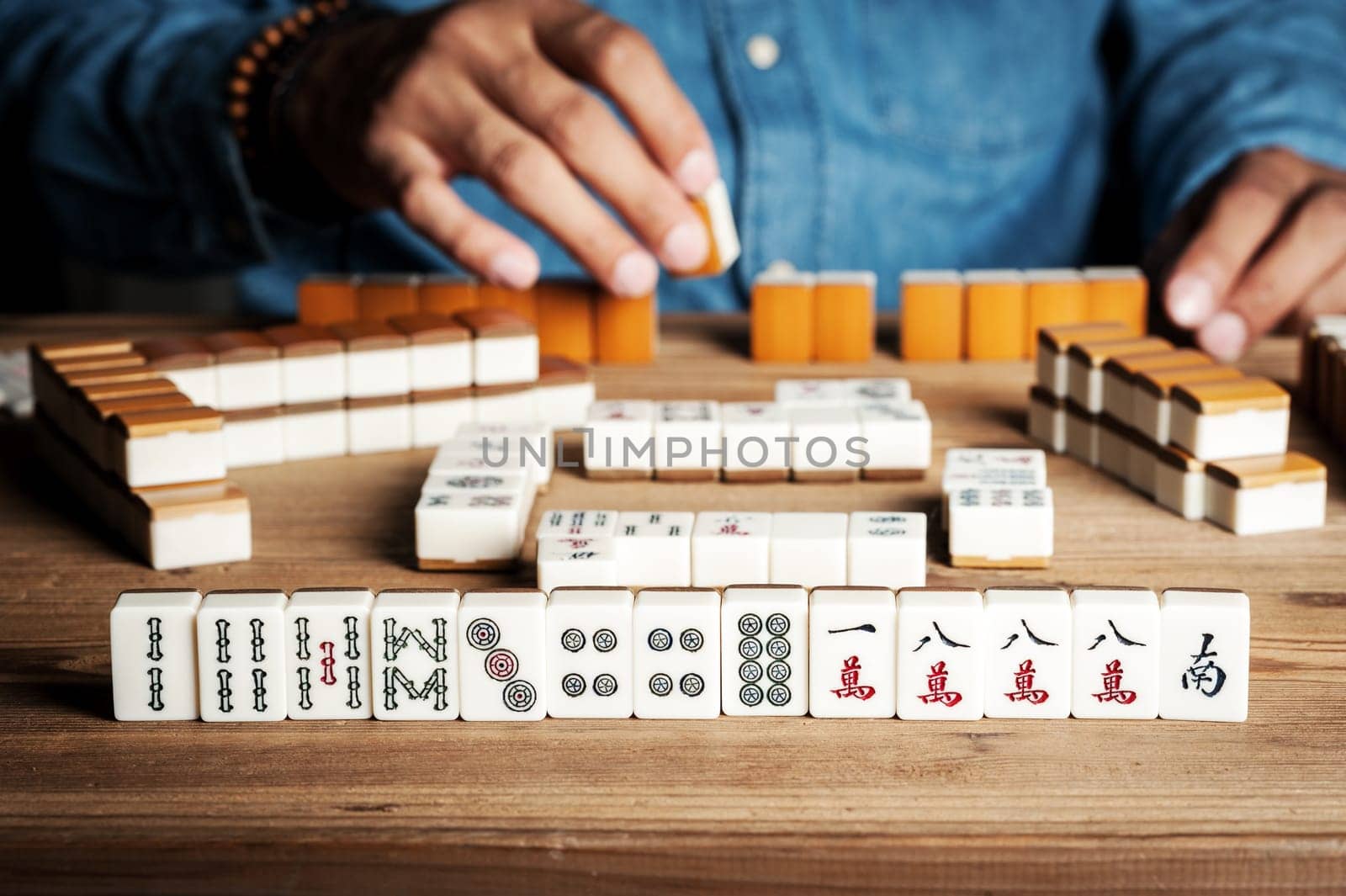 Playing Mahjong on wooden table. Mahjong is the ancient asian board game.