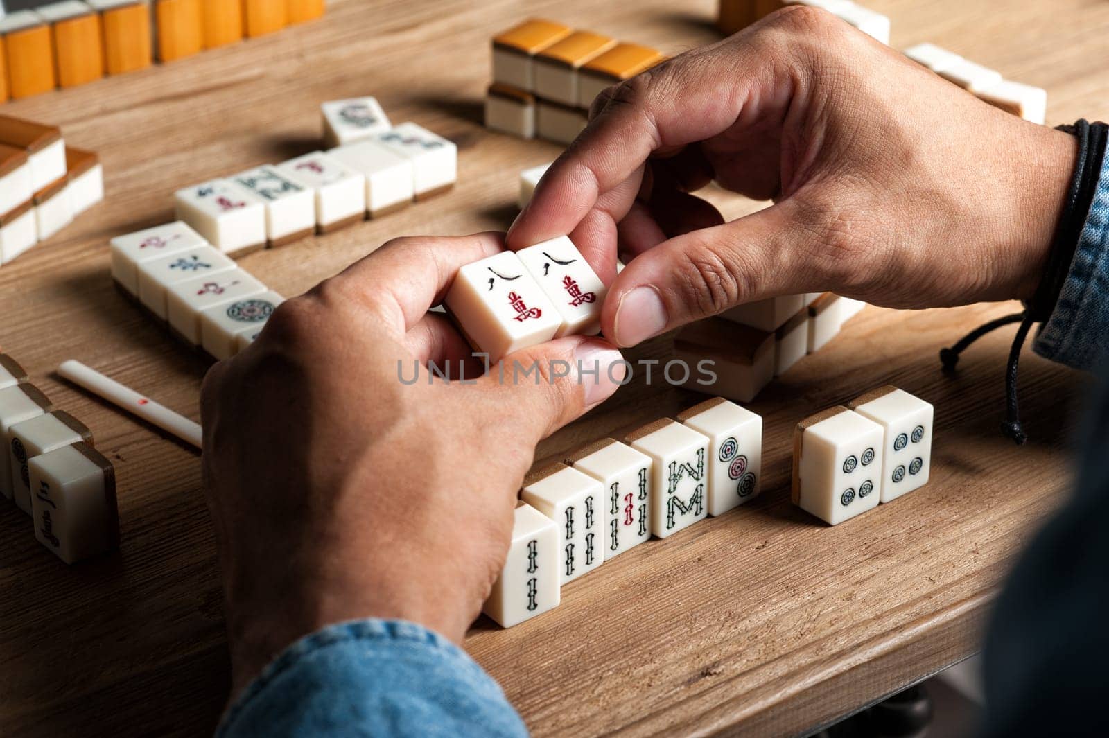 Playing Mahjong on wooden table. Mahjong is the ancient asian board game.