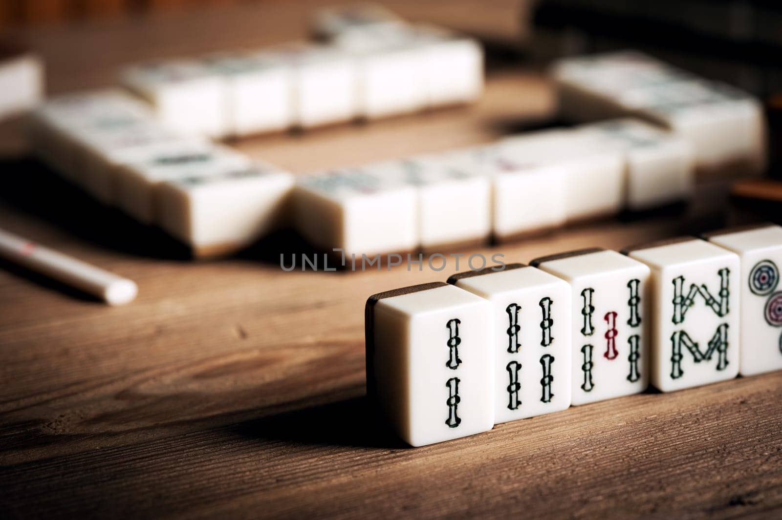 Playing Mahjong on wooden table. Mahjong is the ancient asian board game.