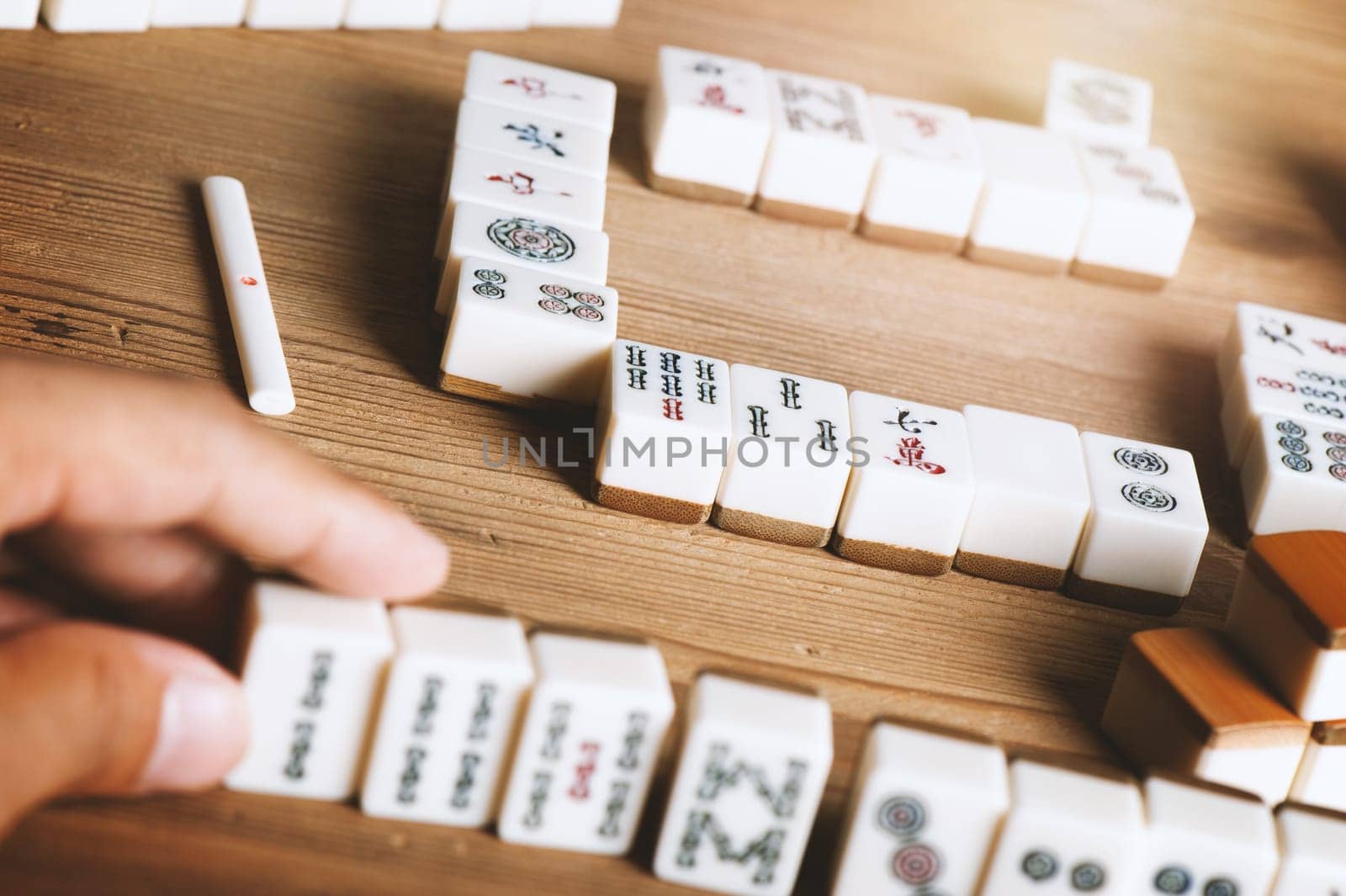 Playing Mahjong on wooden table. Mahjong is the ancient asian board game.