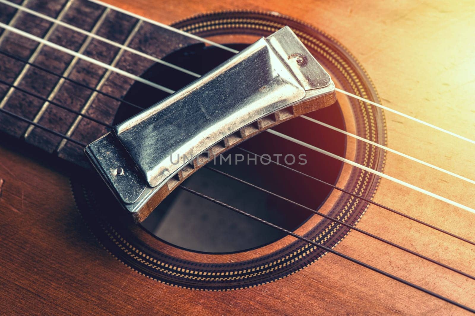 vintage harmonica on acoustic guitar by norgal