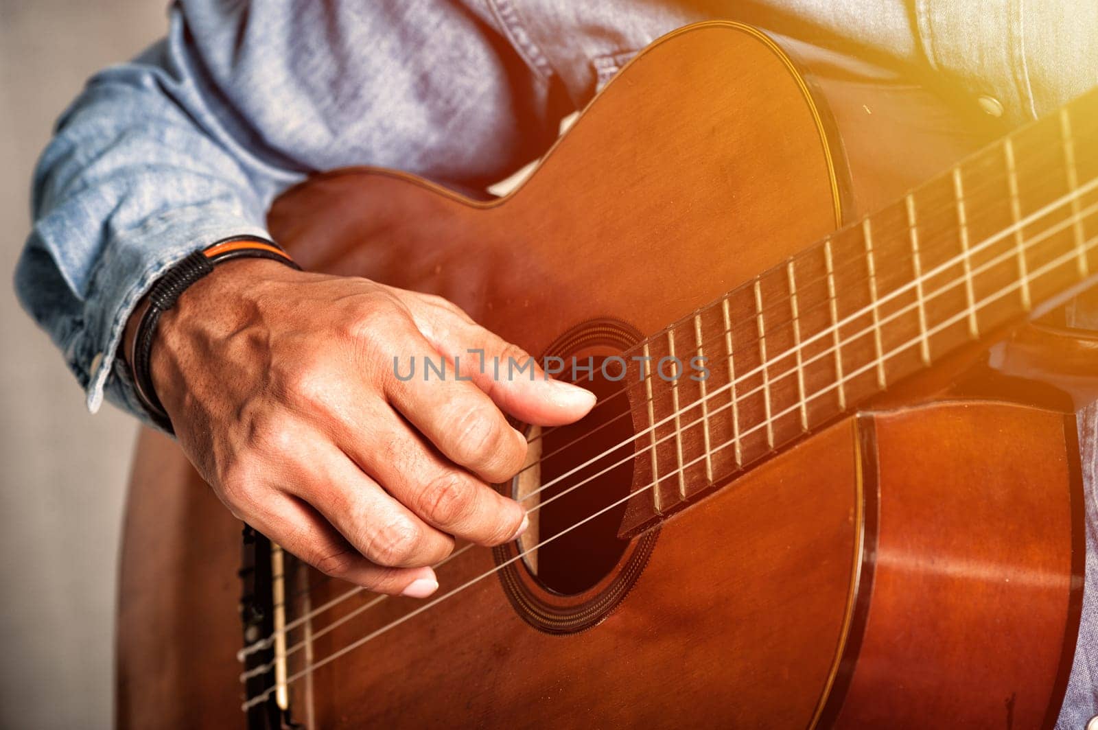 closeup man's hand playing his old classical guitar.