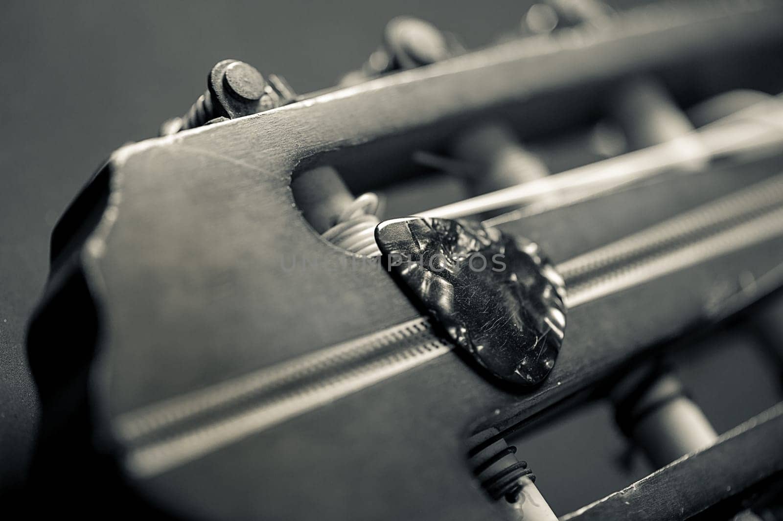 Closeup guitar pick on an old classical guitar. A guitar pick is a plectrum used for guitars.