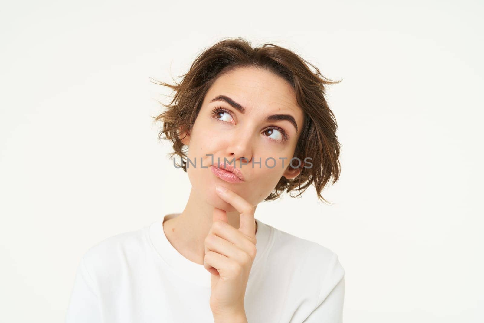 Close up portrait of woman with thoughtful face, thinking of solution, pondering, making choice, standing over white studio background.