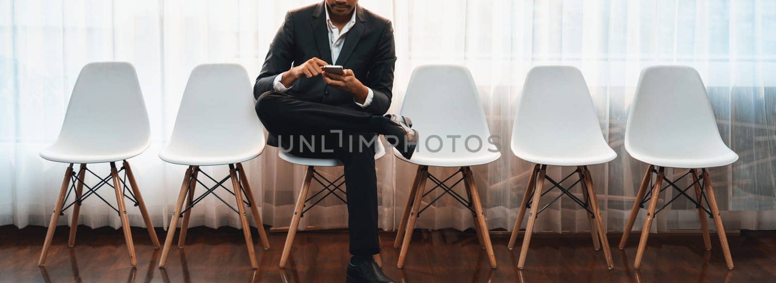 Job applicant waiting for interview in waiting room alone with empty chair on the corridor while applying on job application form. Modern employment and career seeker opportunity concept. Trailblazing