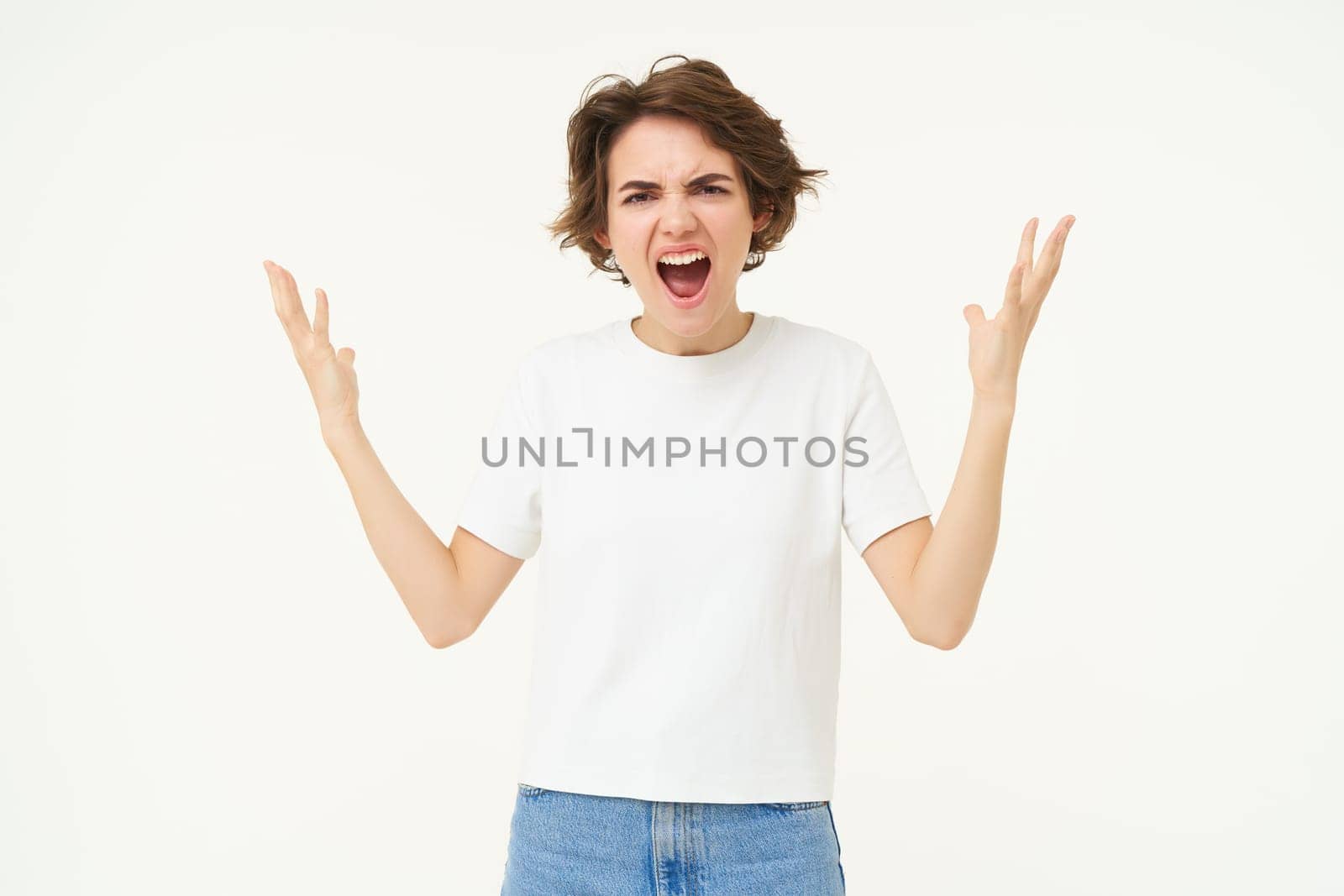 Portrait of angry woman, shaking hands and complaining, furious from frustration and disappointment, standing over white background.