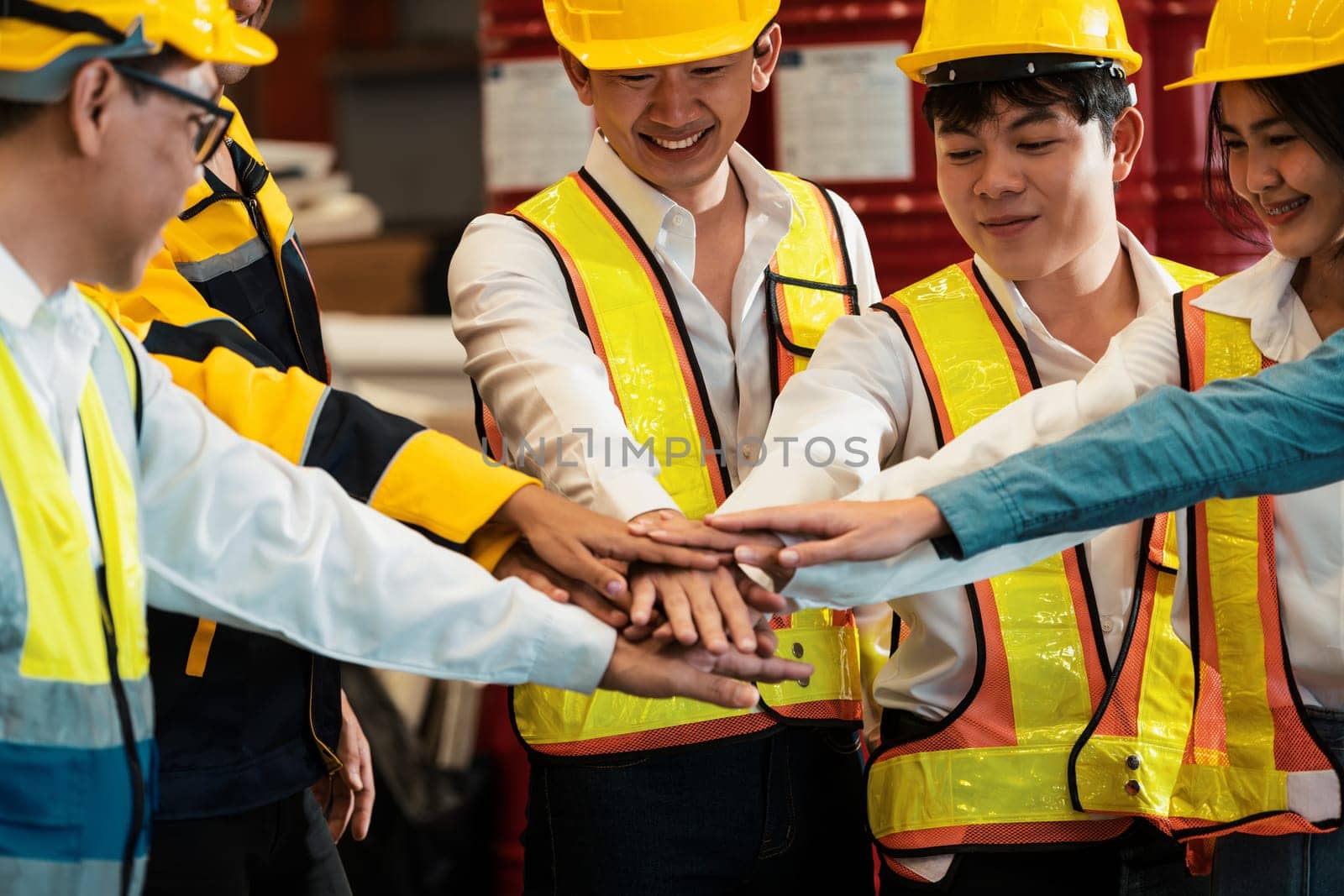 Cohesive and united group of factory worker joining hands. Exemplifying by biancoblue