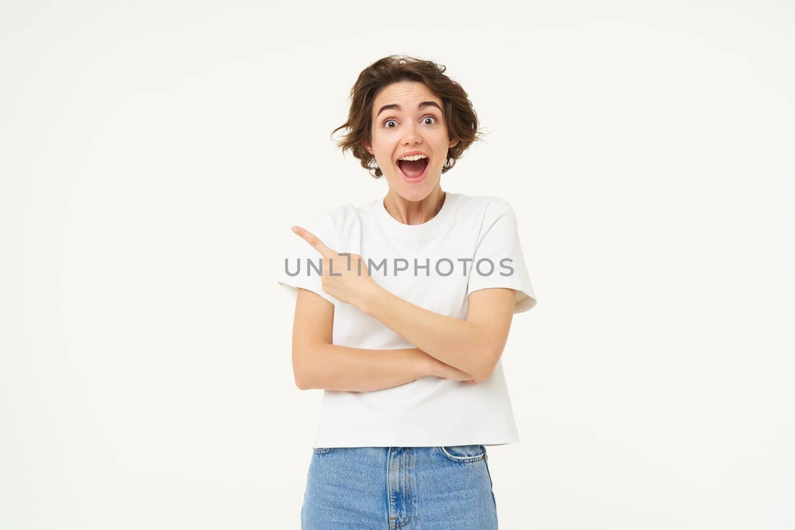 Image of excited woman, pointing finger left, showing advertisement, demonstrating brand banner, standing over white background.