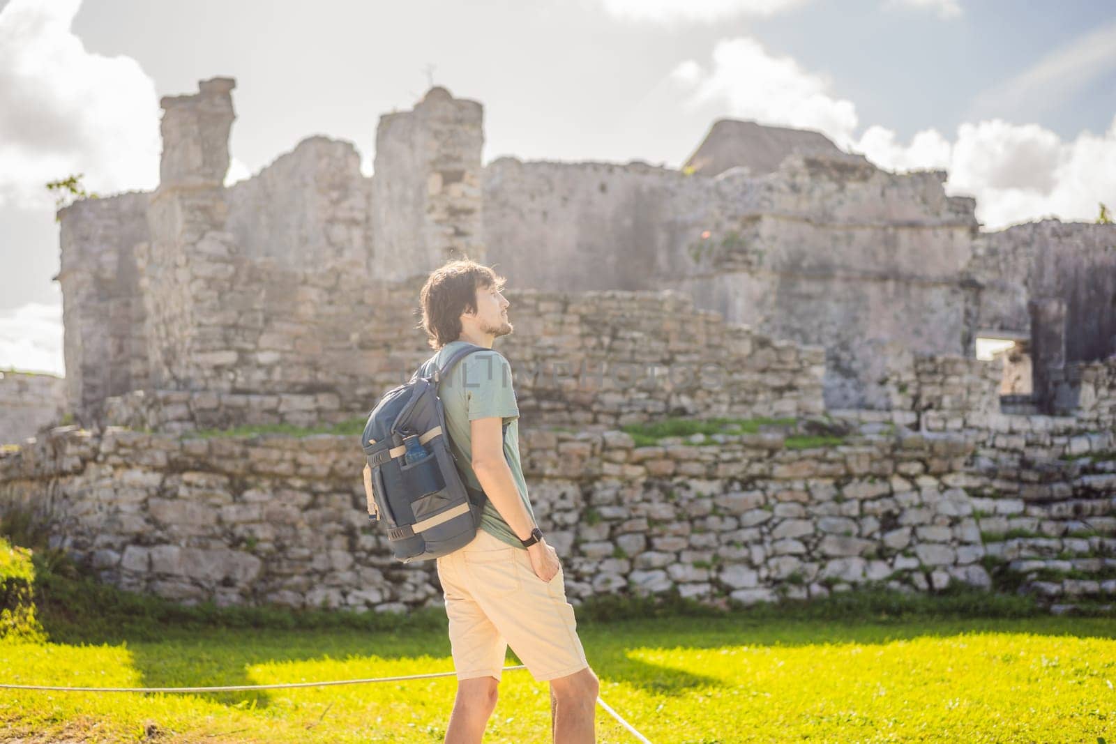 Male tourist enjoying the view Pre-Columbian Mayan walled city of Tulum, Quintana Roo, Mexico, North America, Tulum, Mexico. El Castillo - castle the Mayan city of Tulum main temple.