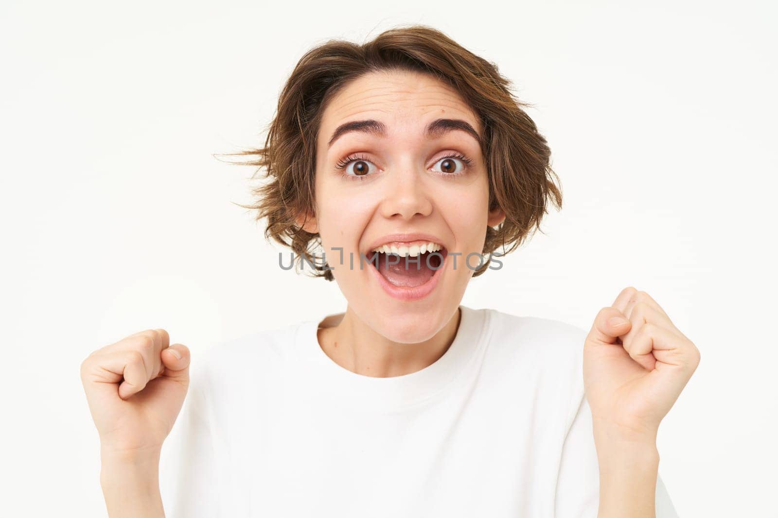 Close up portrait of excited woman, gasping and smiling, looking surprised, amazed by great news, isolated over white background.