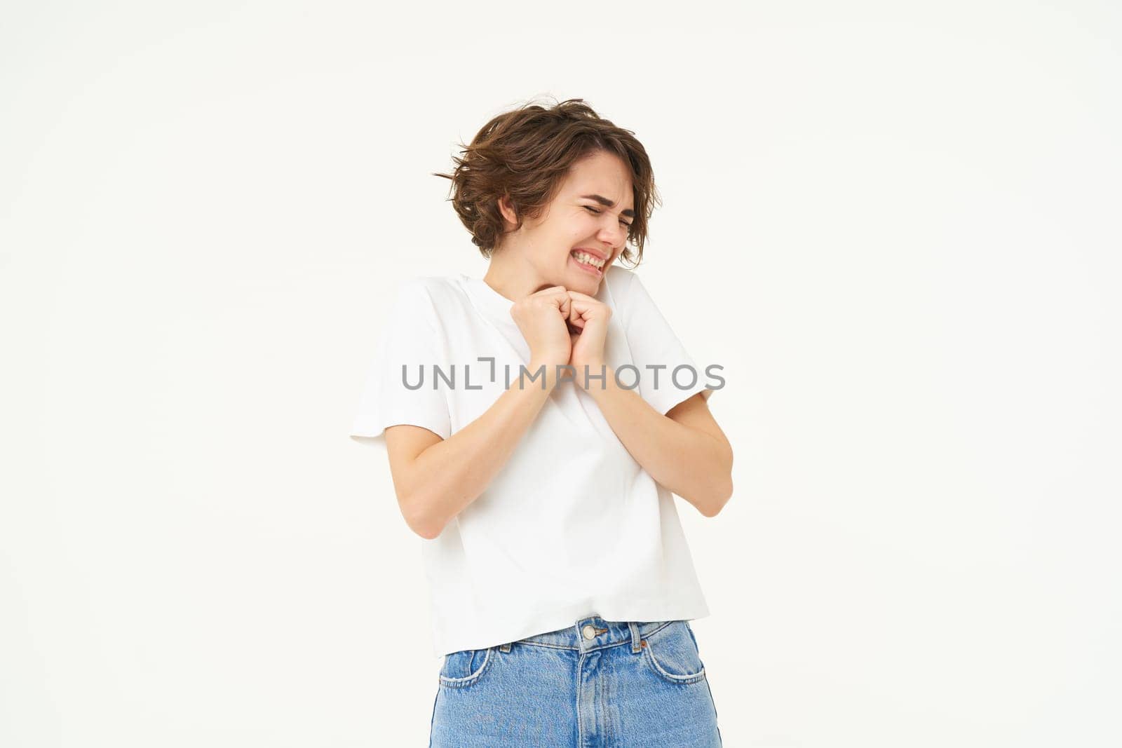Image of woman with scared face, looks frightened, worried, trembling from fear, isolated against white background.