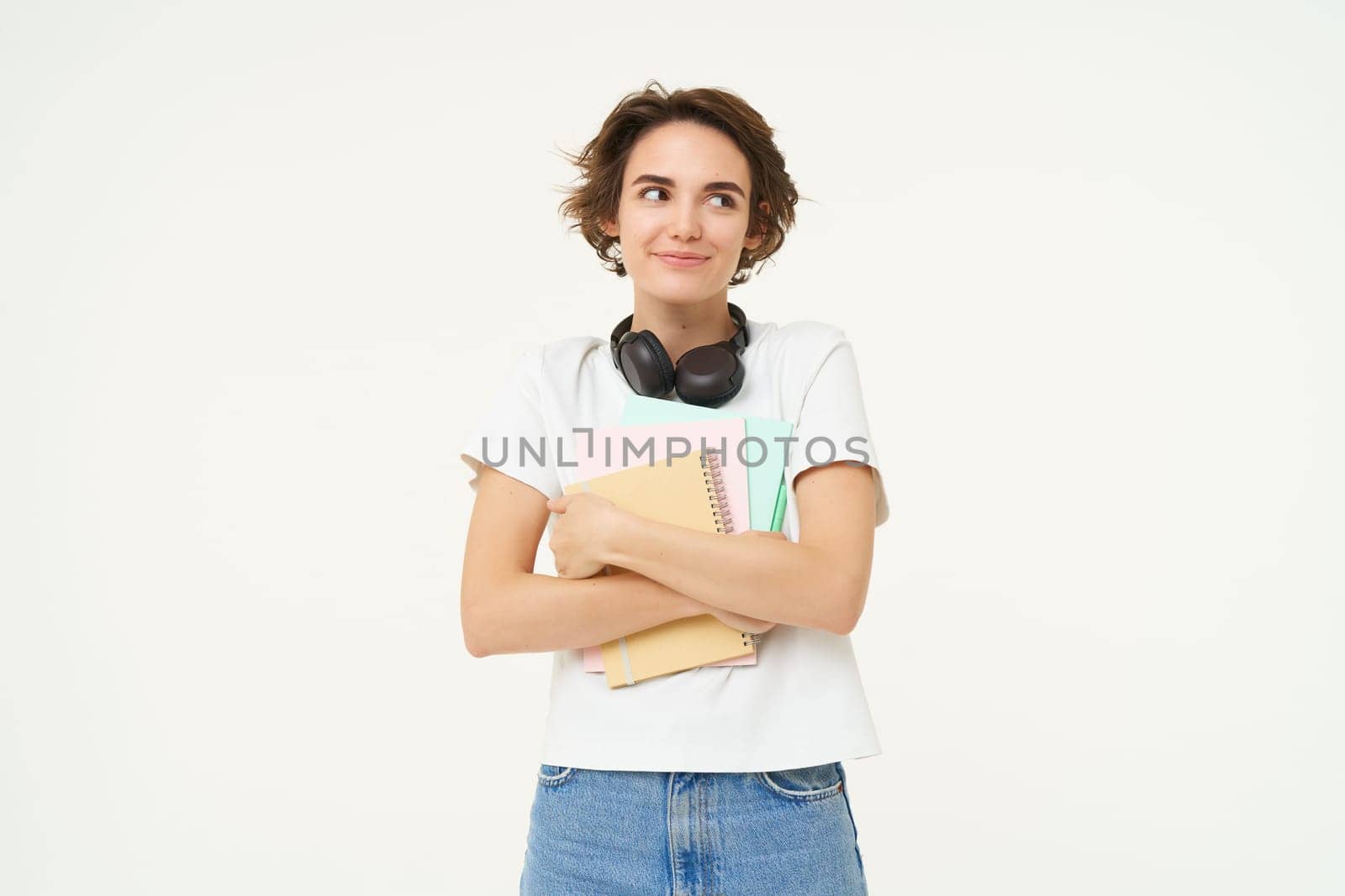 Image of stylish, modern girl student, holding workbook, documents. Woman teacher with papers standing over white background.