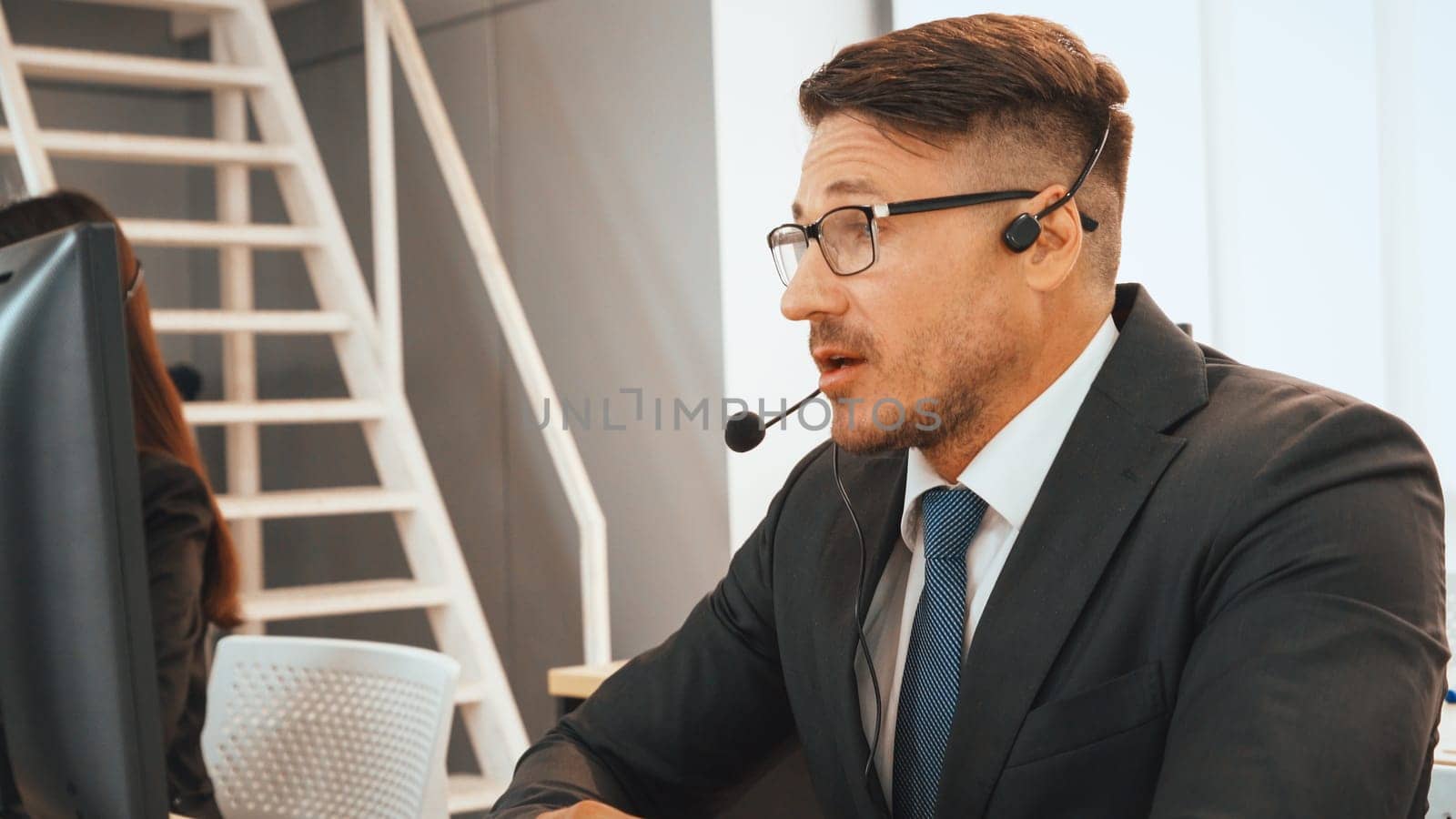 Business people wearing headset working in office to support remote customer or colleague. Call center, telemarketing, customer support agent provide service on telephone video conference call. Jivy